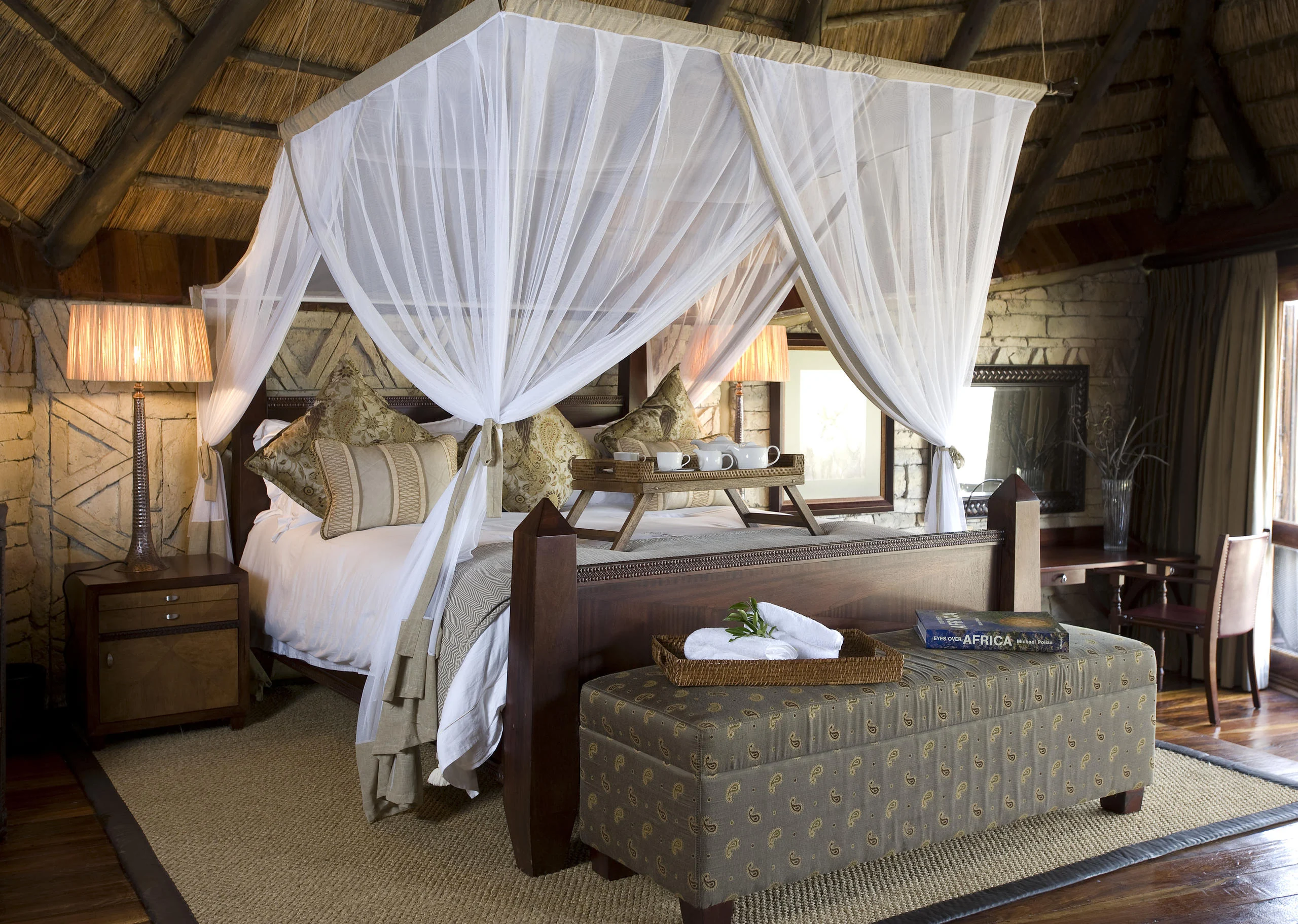 A bedroom with a draped four-poster bed