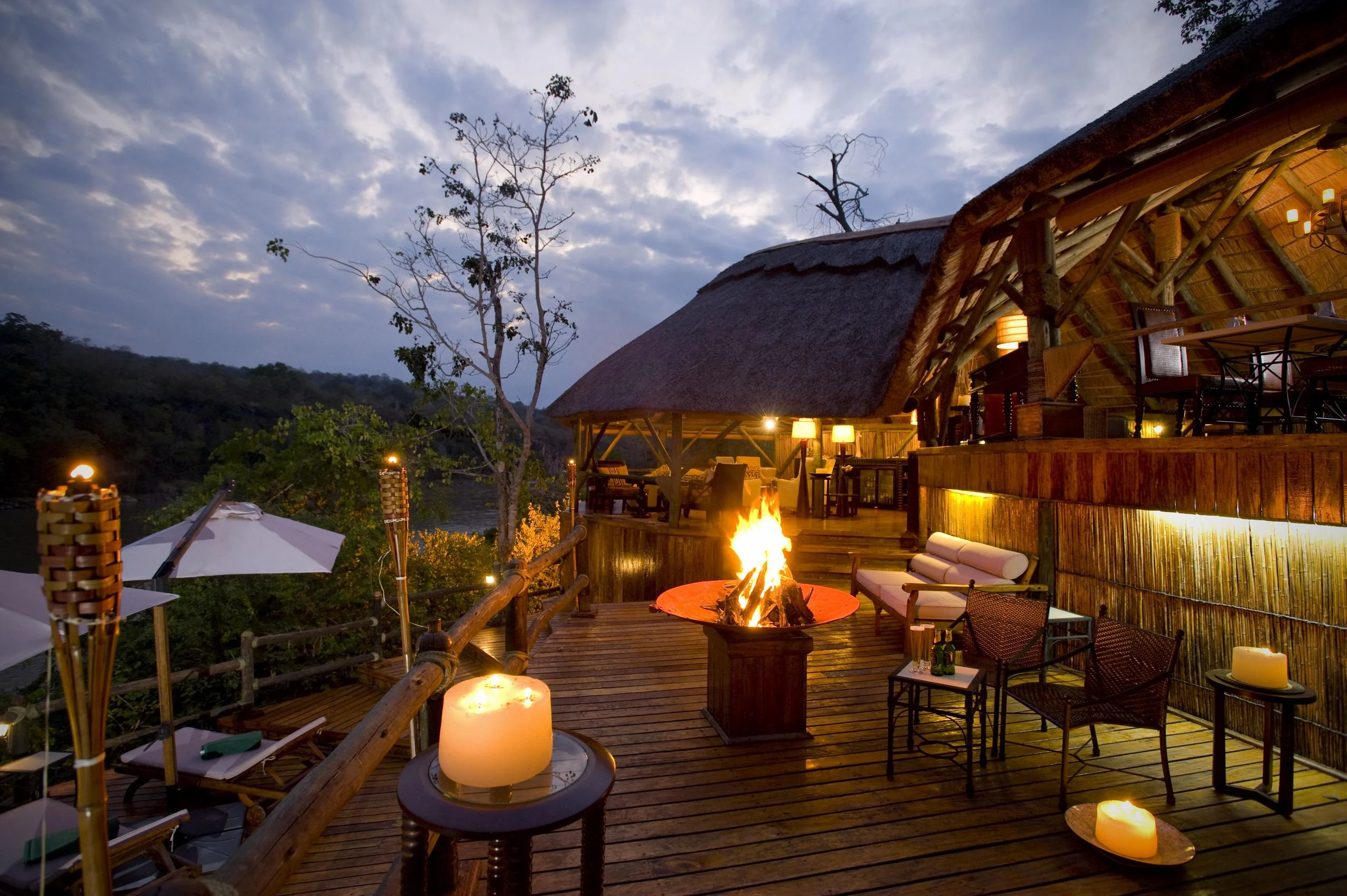The deck at dusk with a fire and lanterns