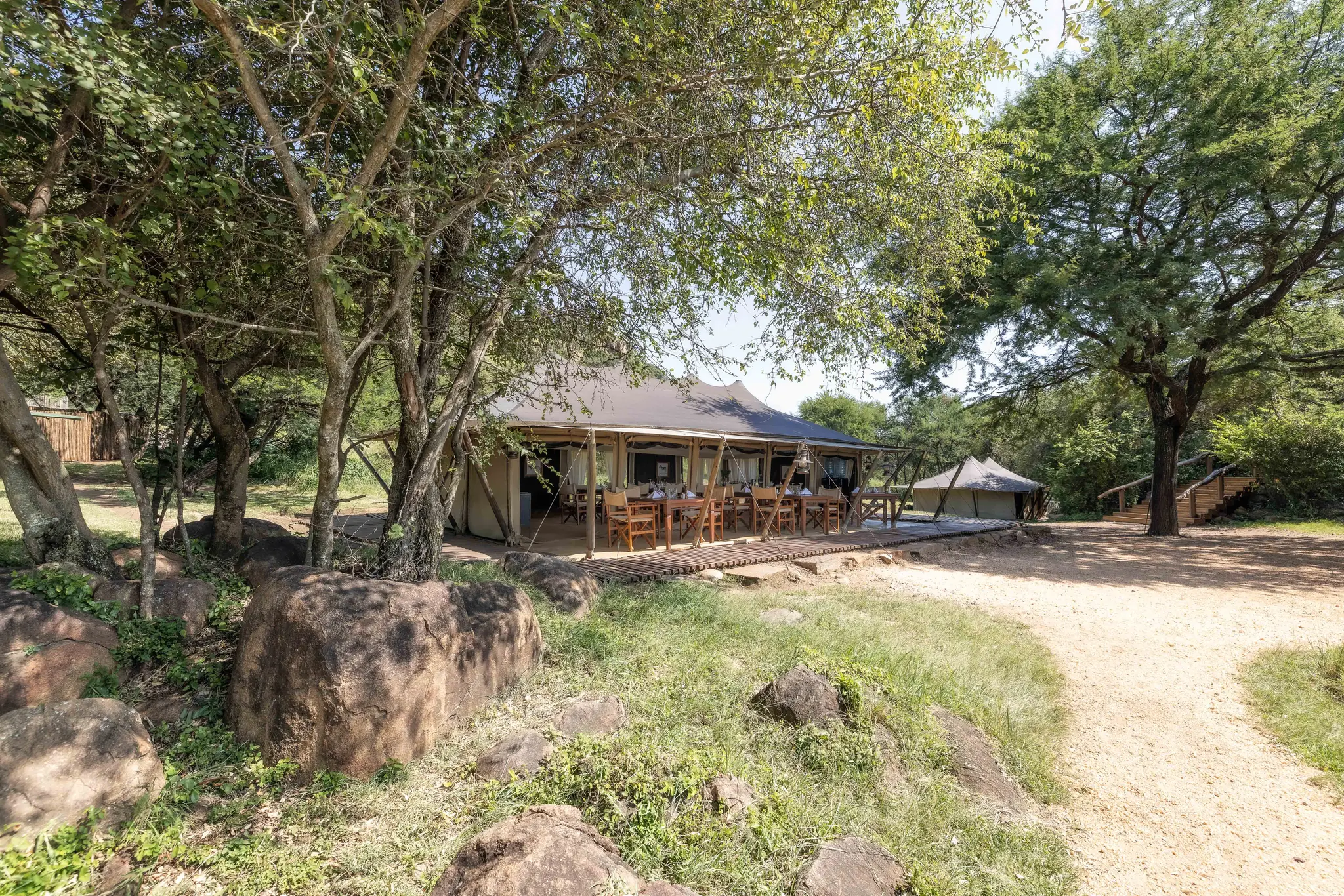 The dining tent among trees and rocks at Serengeti Pioneer Camp