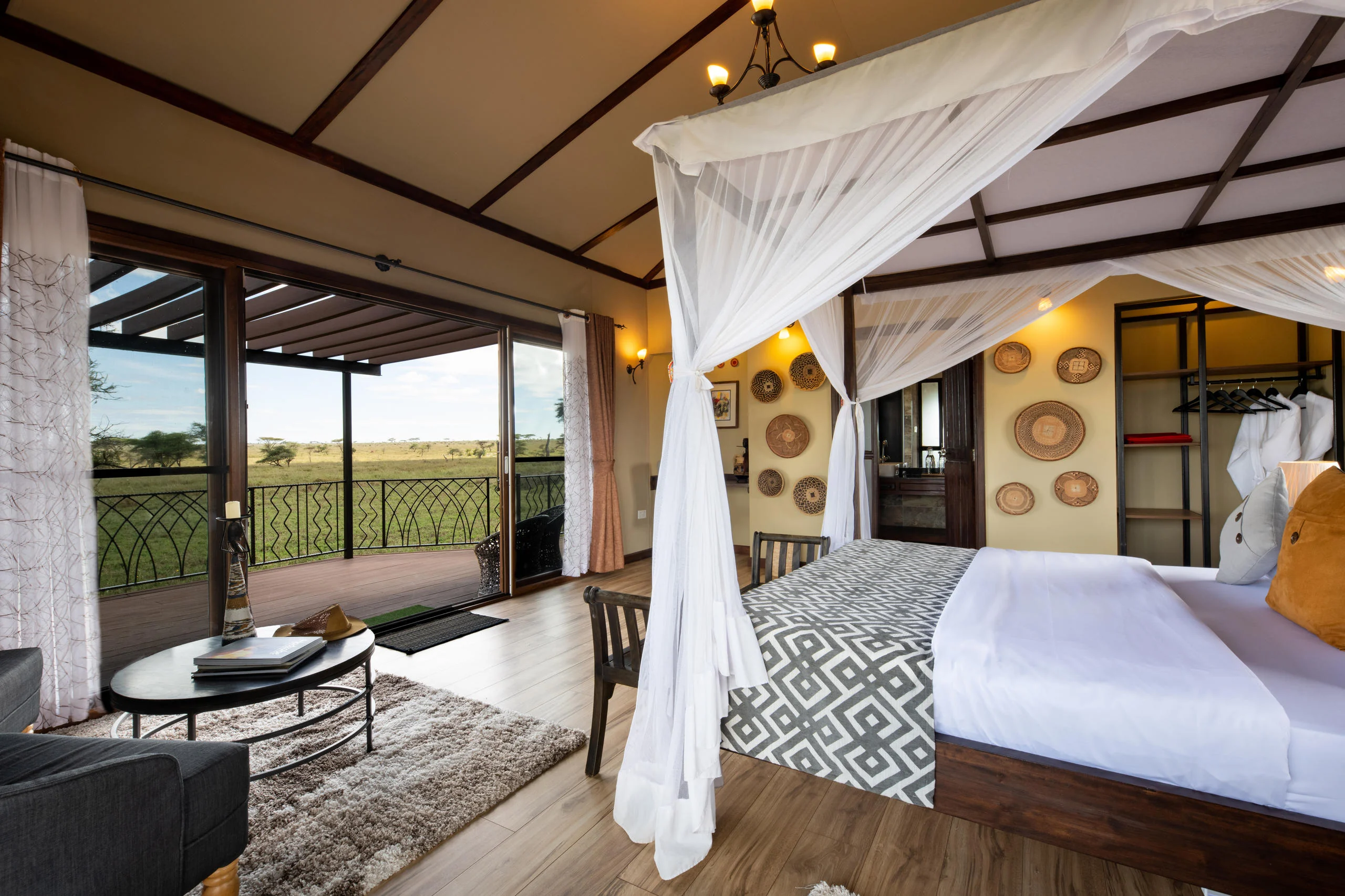 A bedroom with a draped bed and doors onto the deck