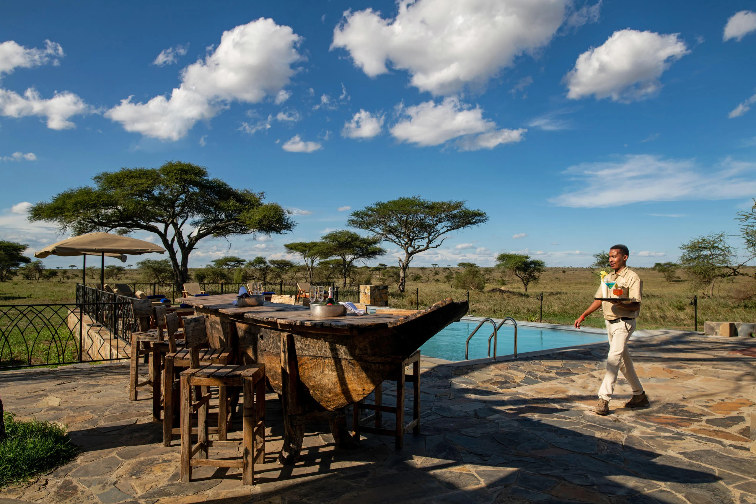 Tables beside the pool with a member of staff