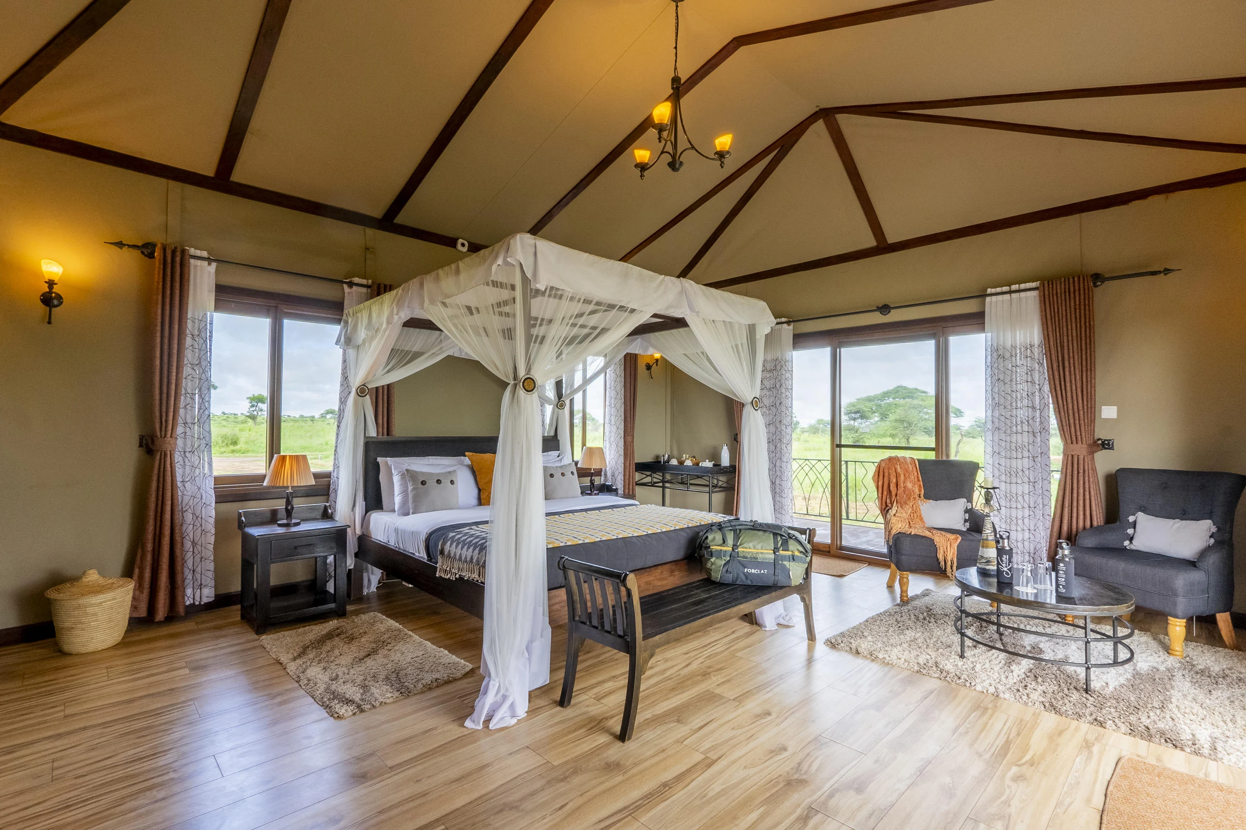 A bedroom with a draped bed and a sitting area