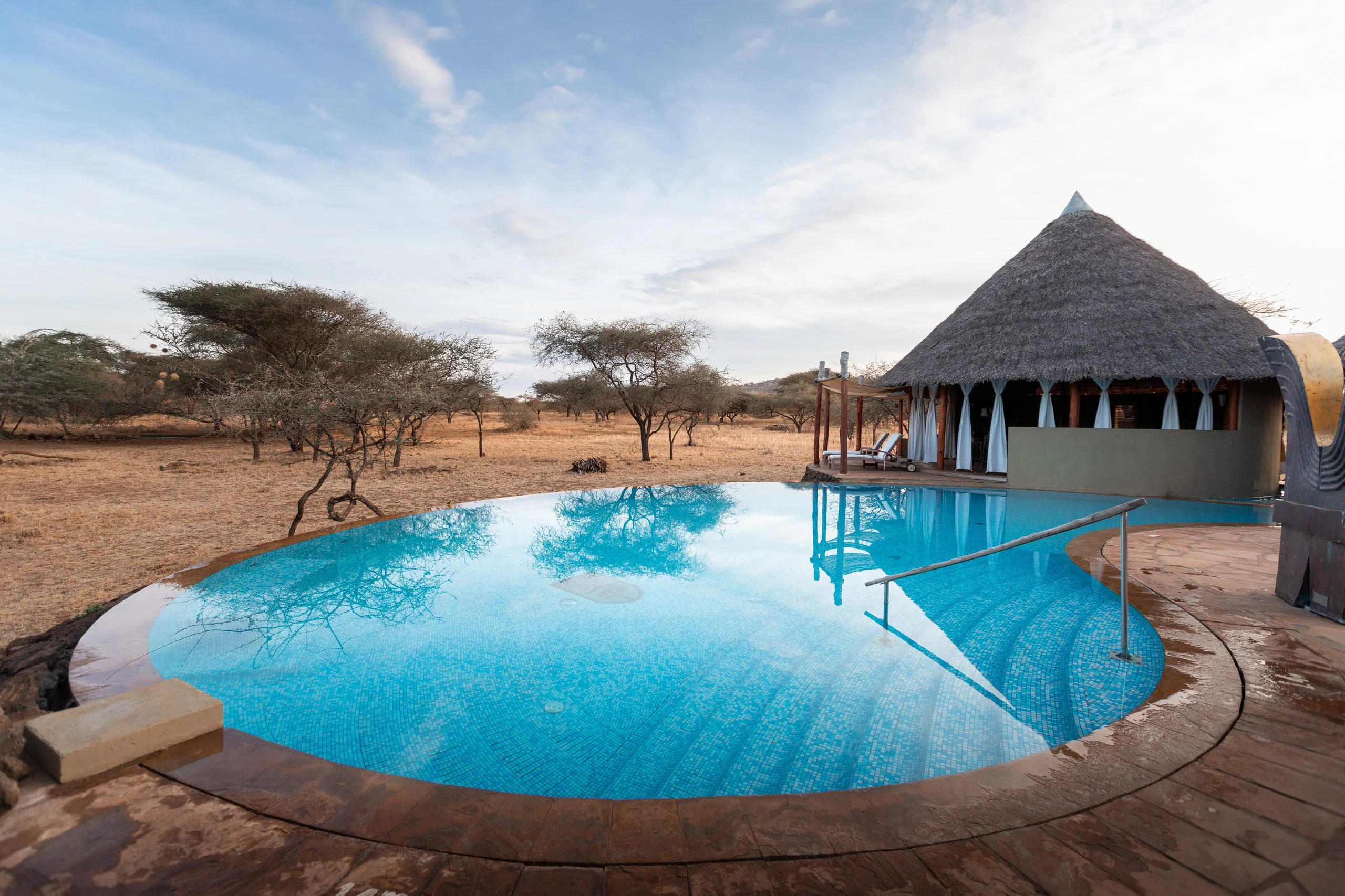 The pool with a thatched banda beyond