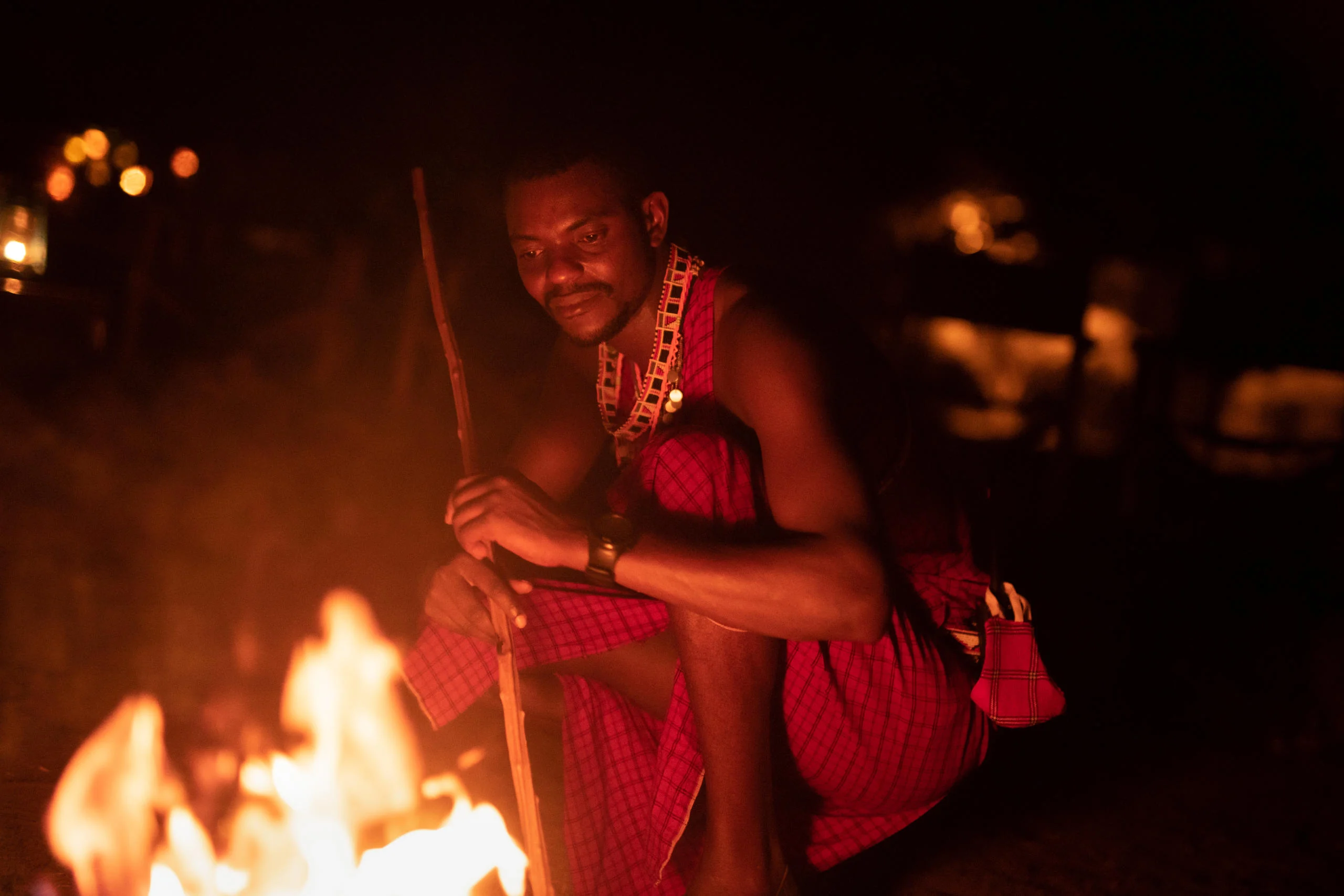 A Maasai guide beside the fire at night