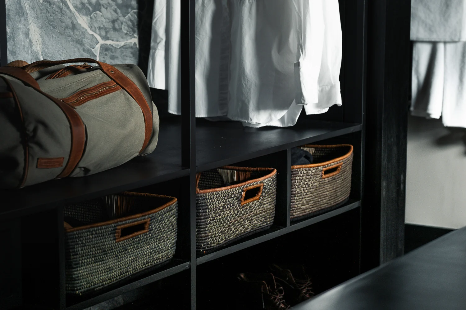 Shelves with baskets and hanging shirts in a dressing area