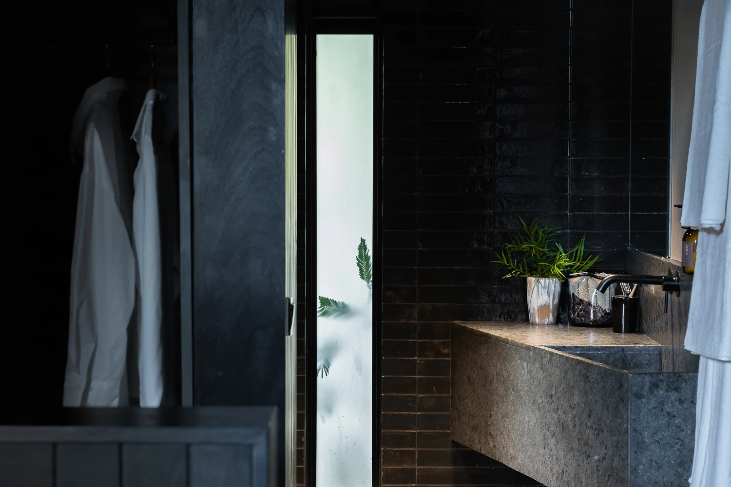 A bathroom with a stone basin and a dressing gown