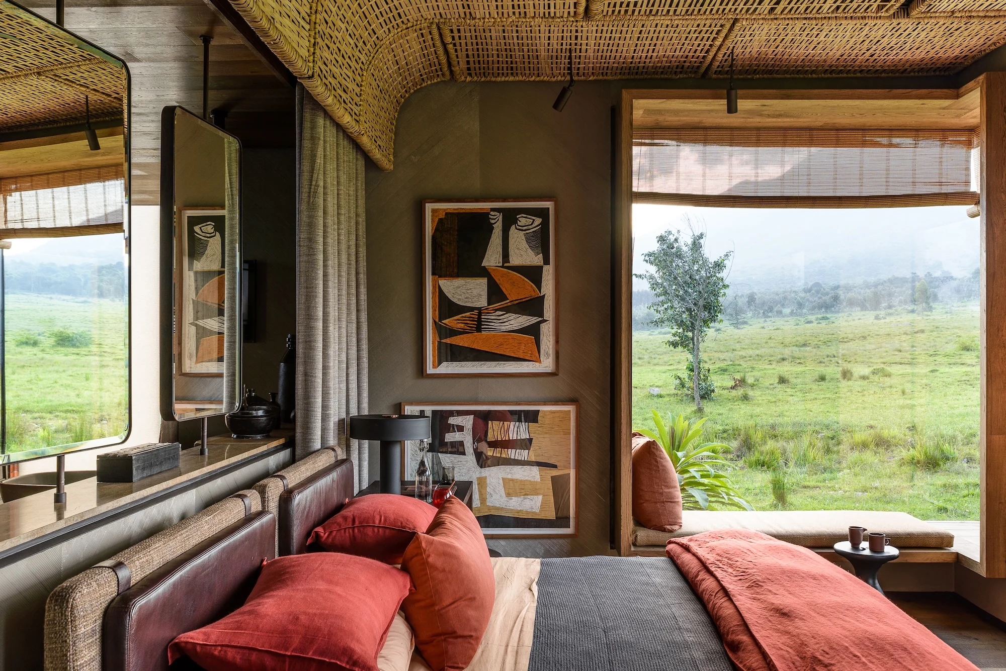 A suite bedroom with red cushions looking out to the volcanoes