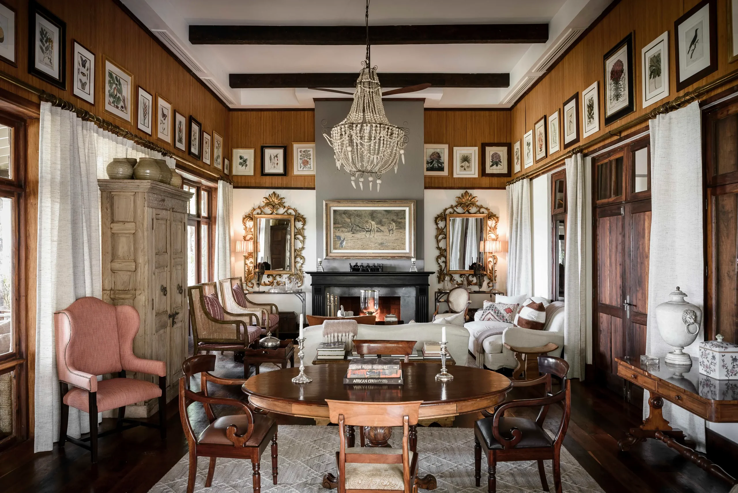 The drawing room with a fireplace, chandelier and framed prints