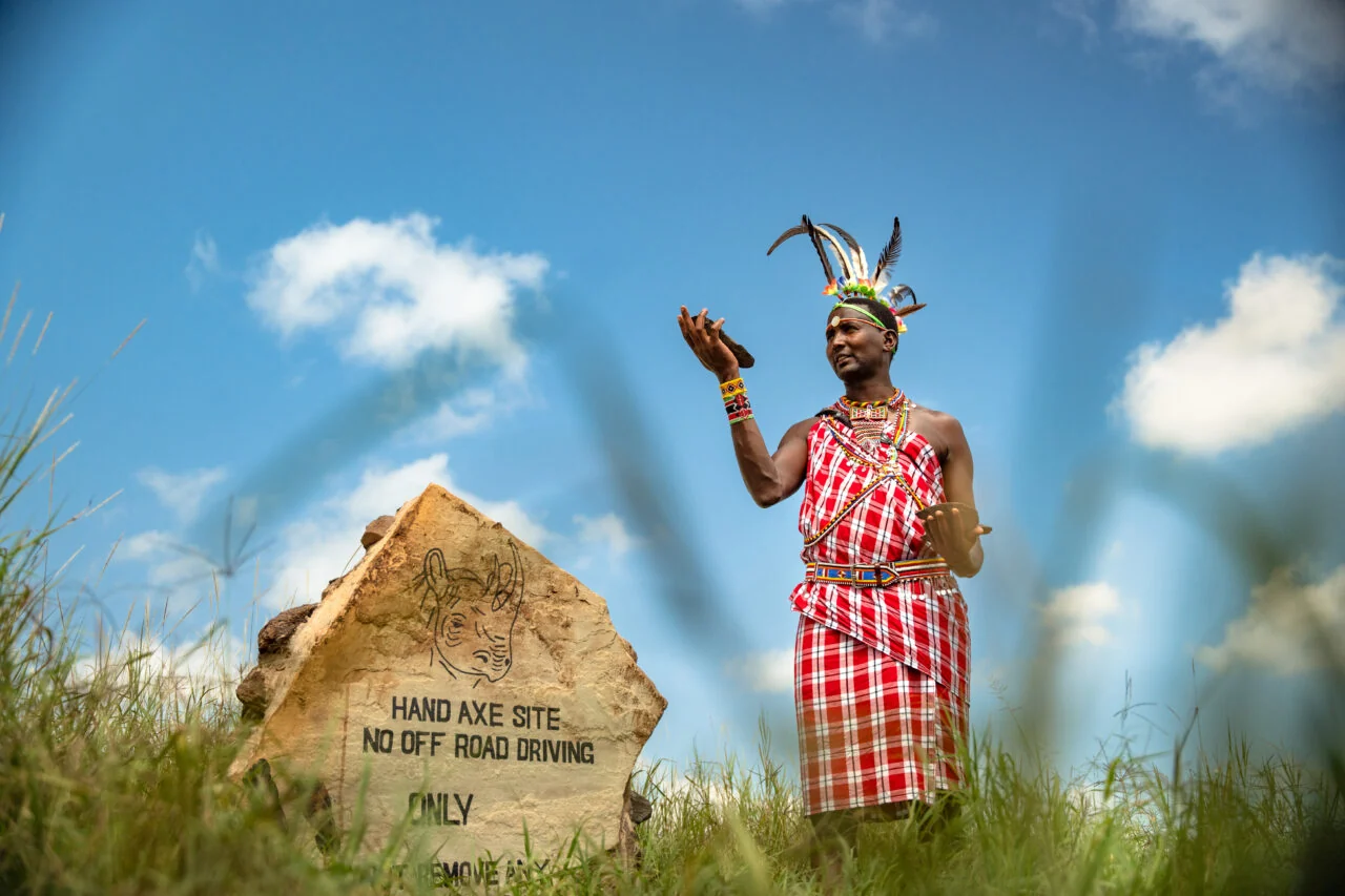 A Maasai guide beside a rock at a prehistoric site
