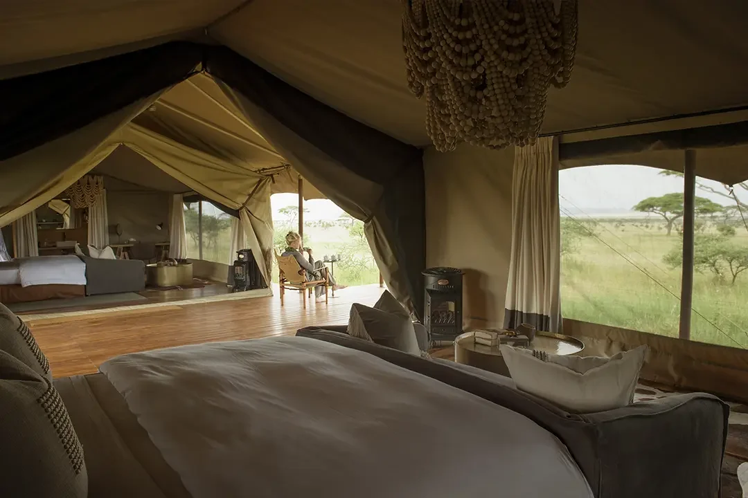 A tent bedroom with the plains beyond the netting