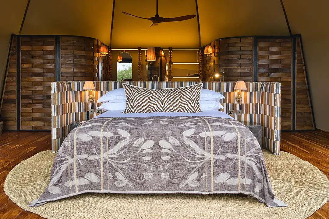 A tent bedroom with a patterned bedspread