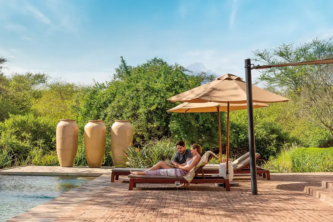Guests on loungers beside the pool