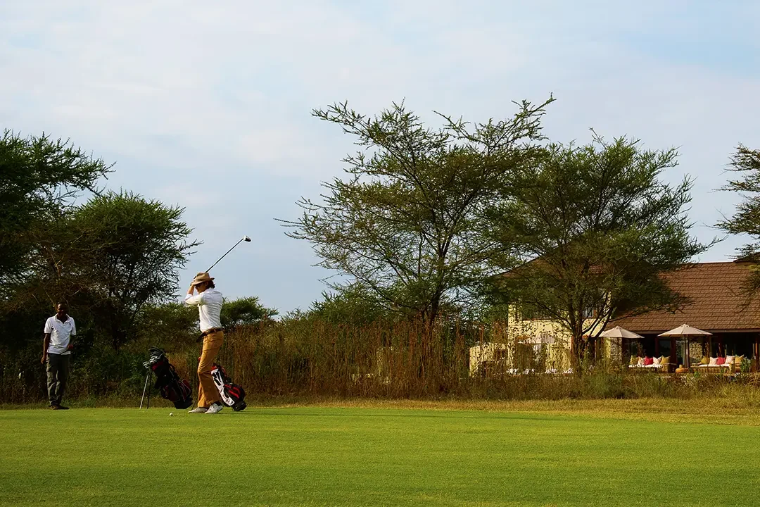 A golfer on the fairway beside the villa
