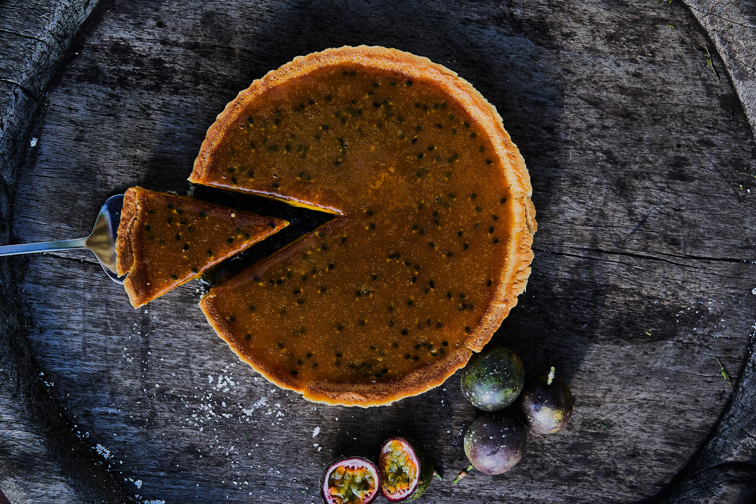 A passion fruit tart on a wooden board