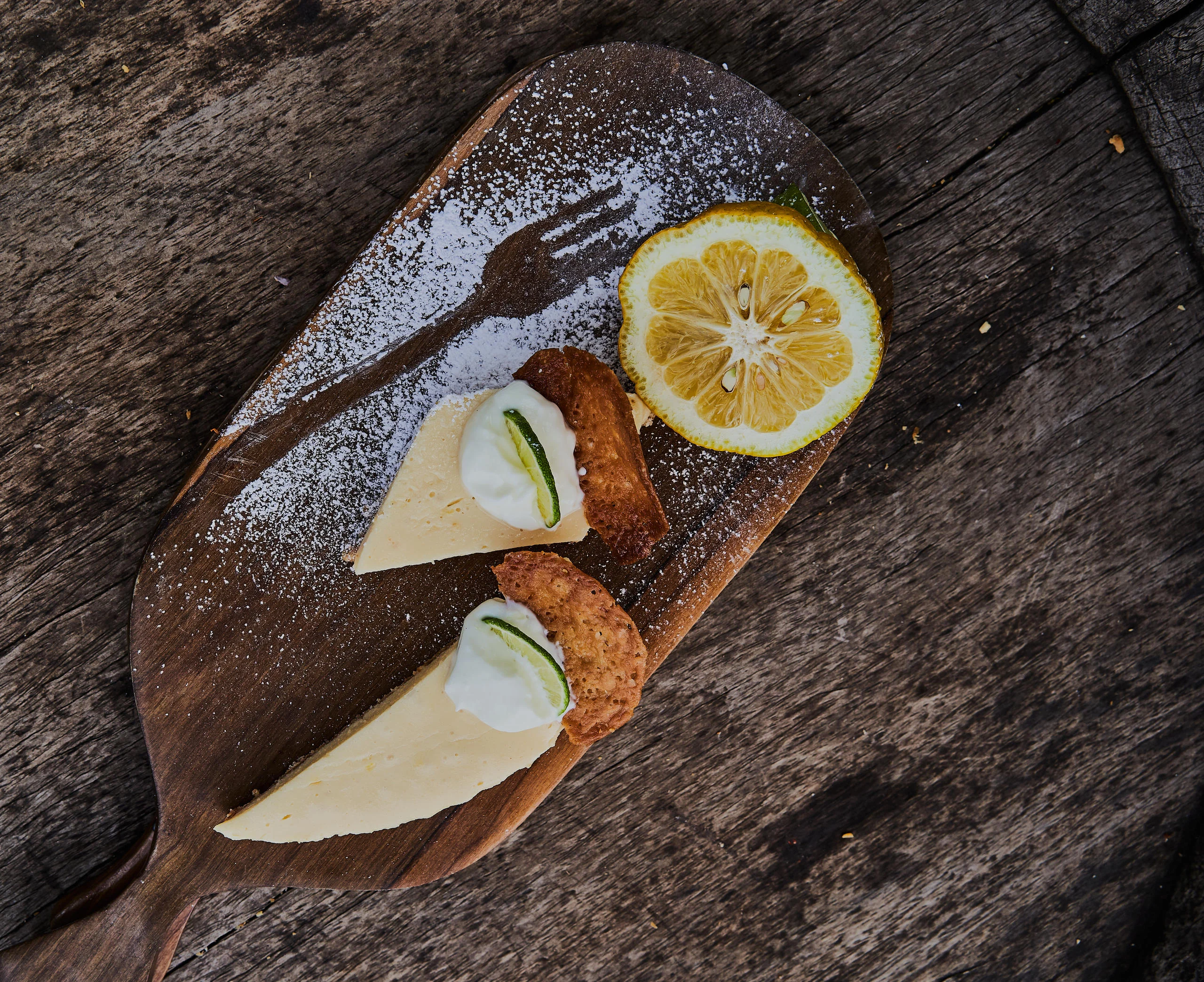 A cake with lemon and cream on a board
