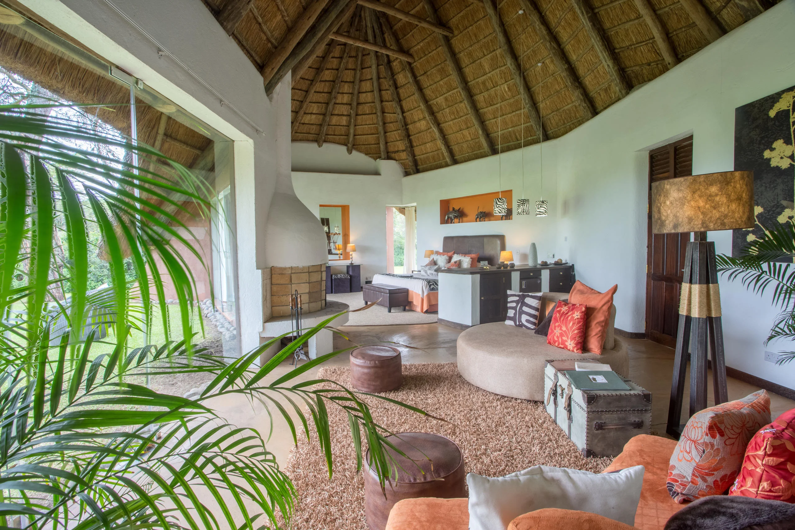 The lounge under thatch with sofas and palms