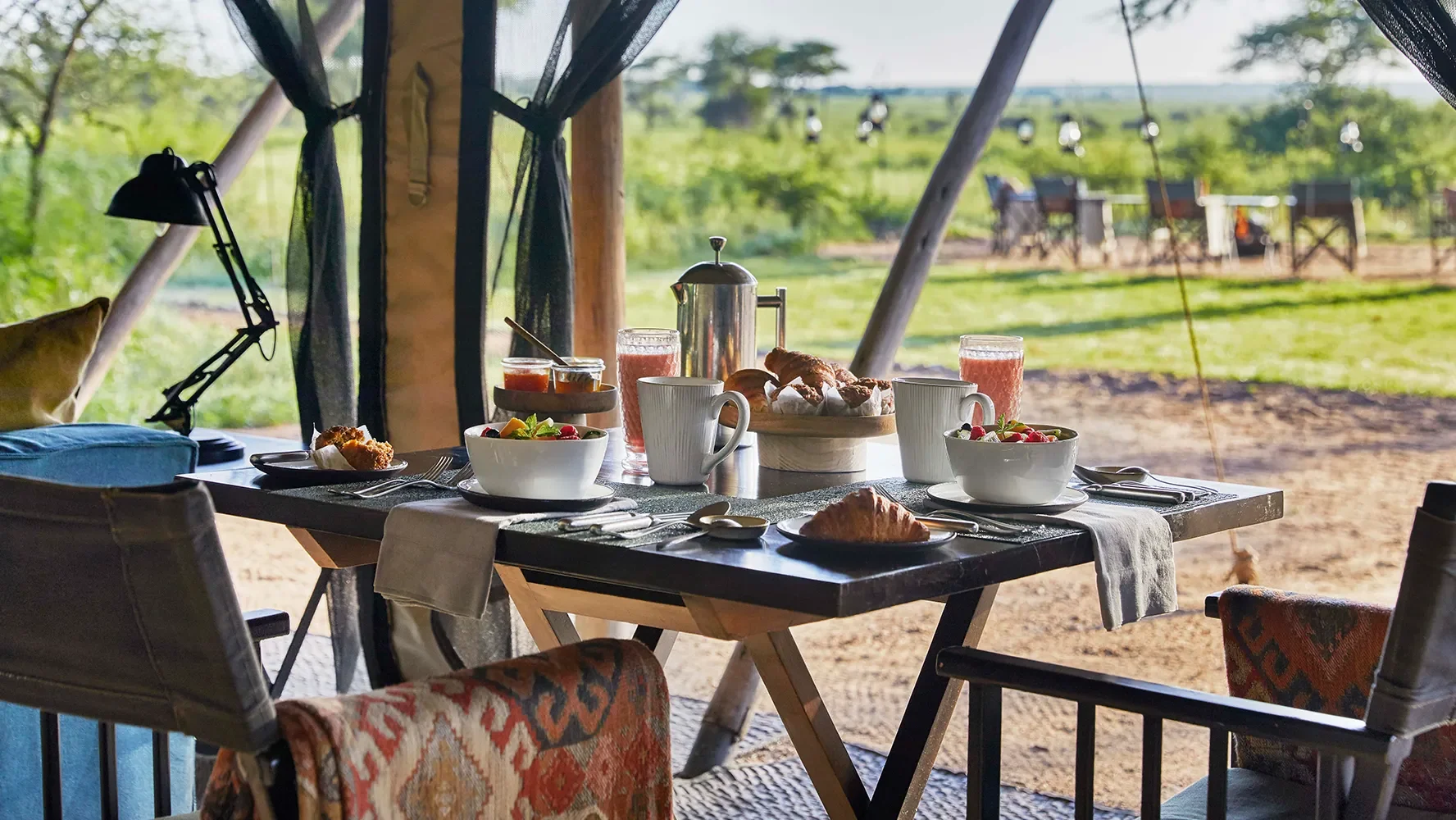 Breakfast laid on a table in a tent, with the plains beyond