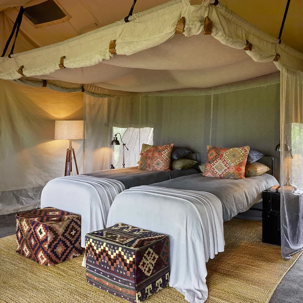 A tent bedroom with twin canopied beds