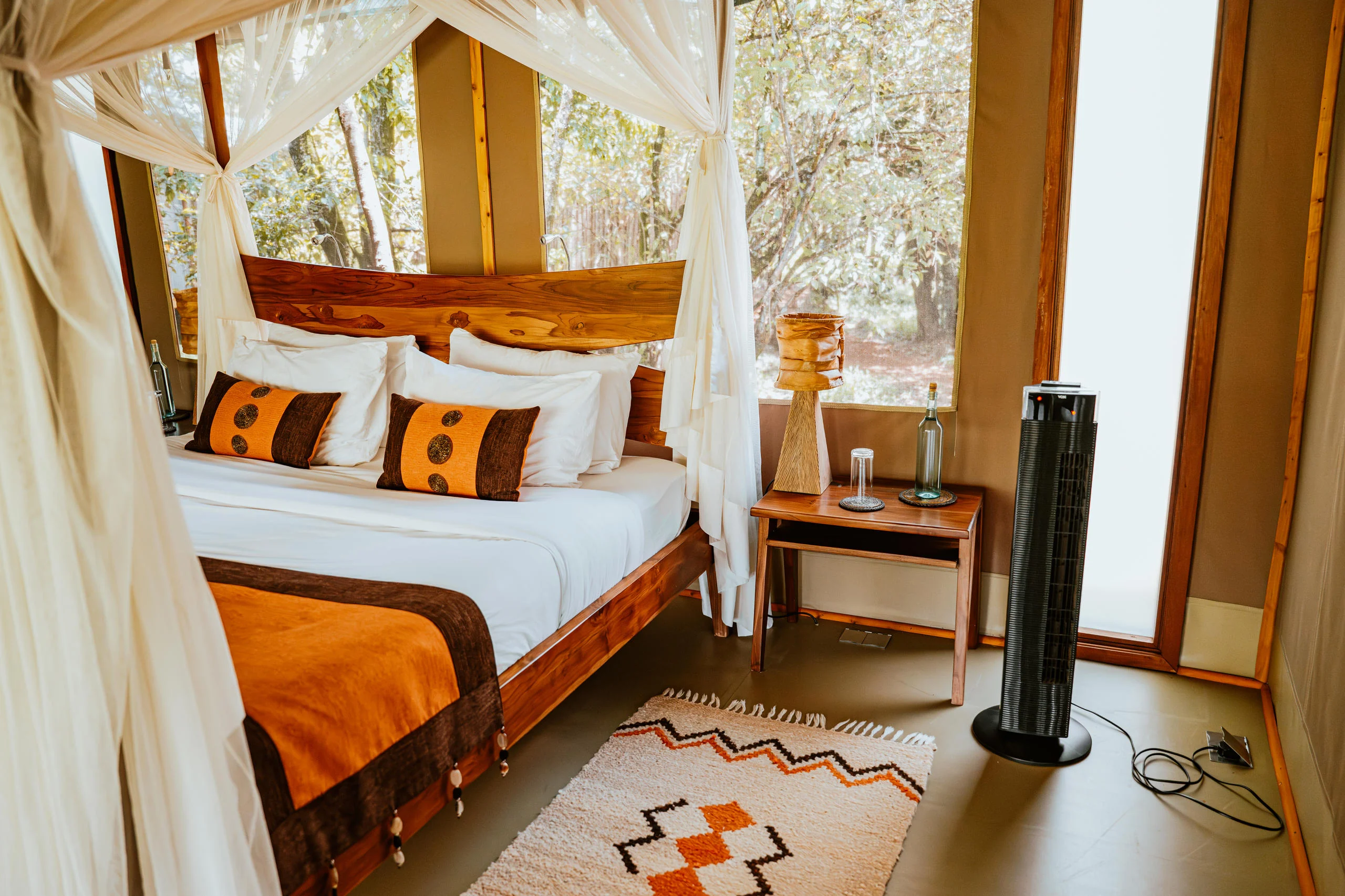 A tent bedroom with a draped four-poster bed