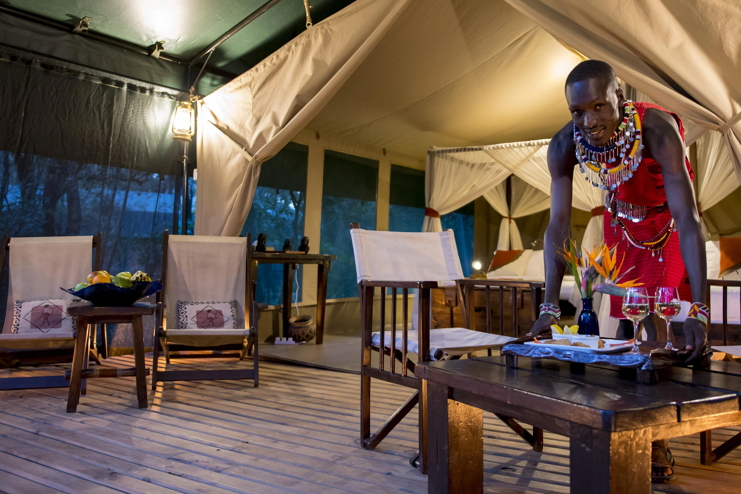 A Maasai member of staff serving on a tent deck