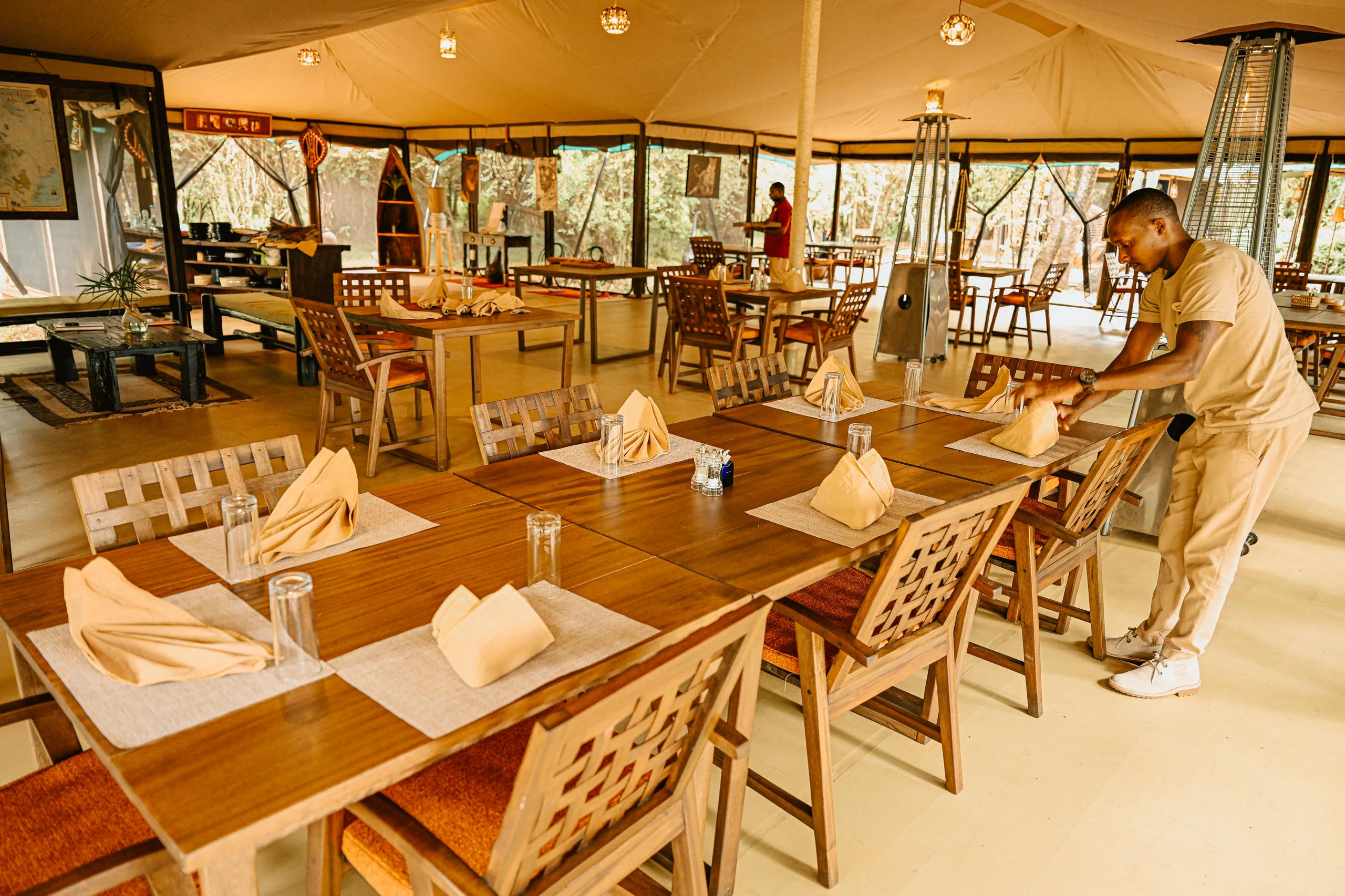 The dining tent with a member of staff laying tables