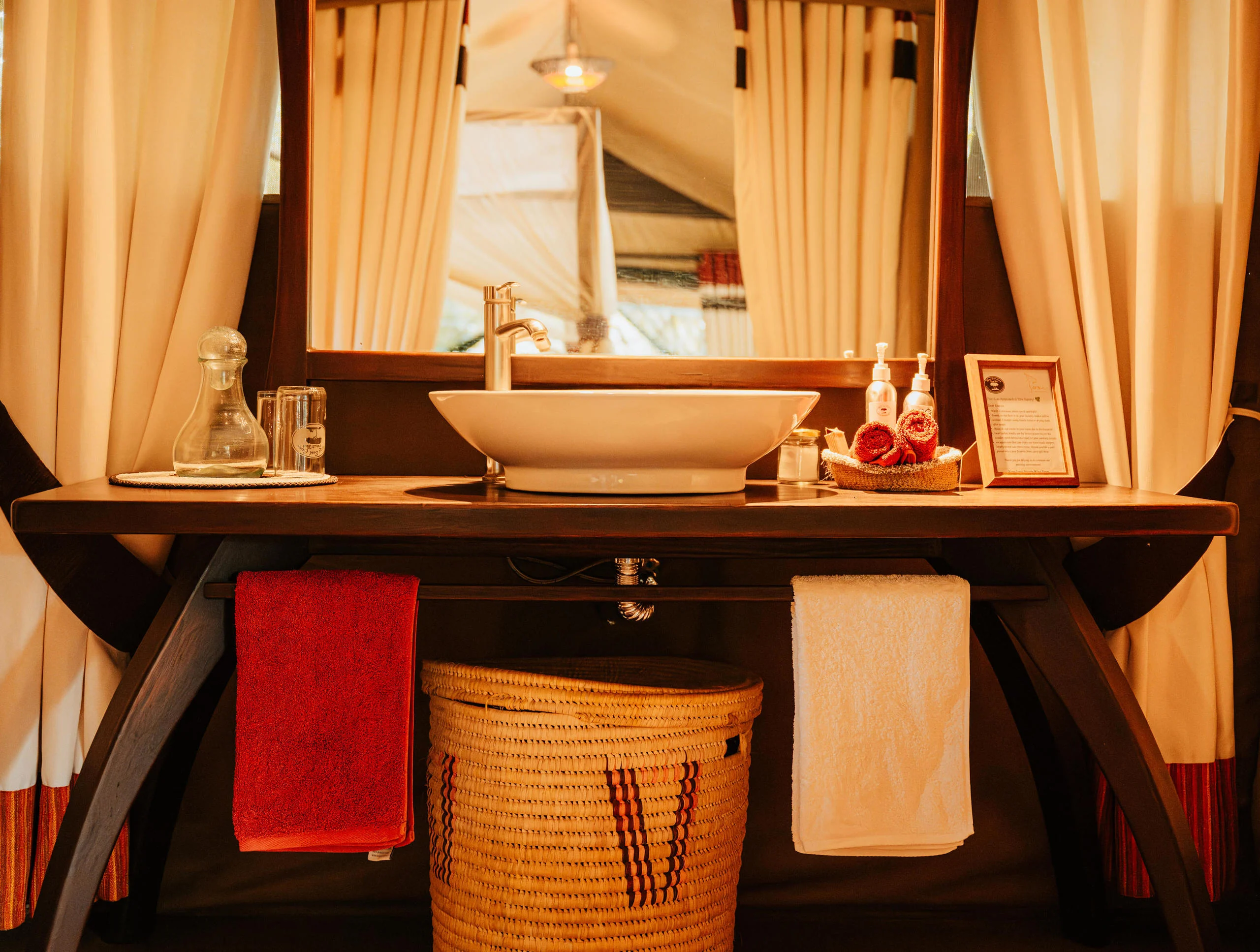 A tent washstand with a basin and red towels