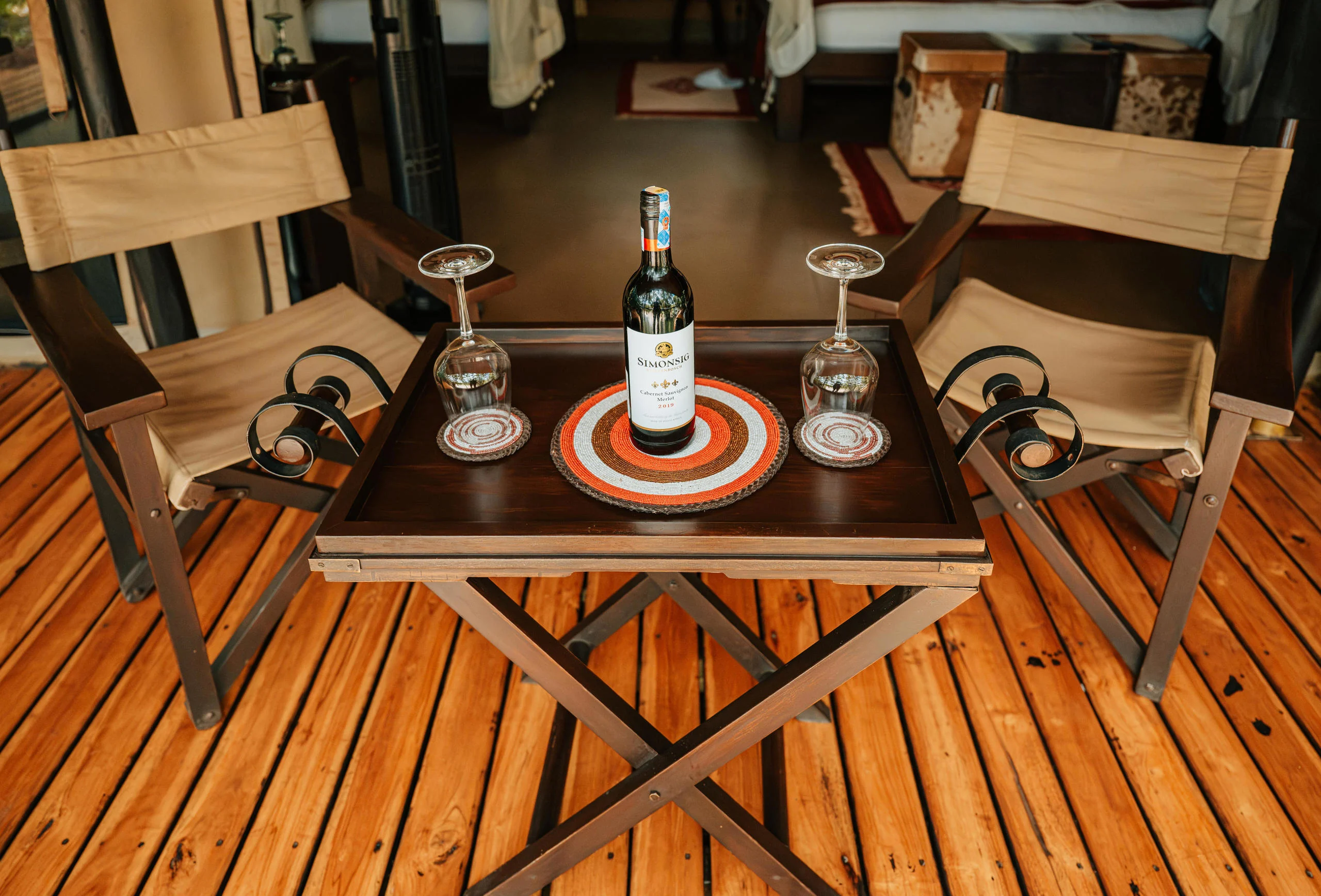 A bottle and glasses on a tent deck table