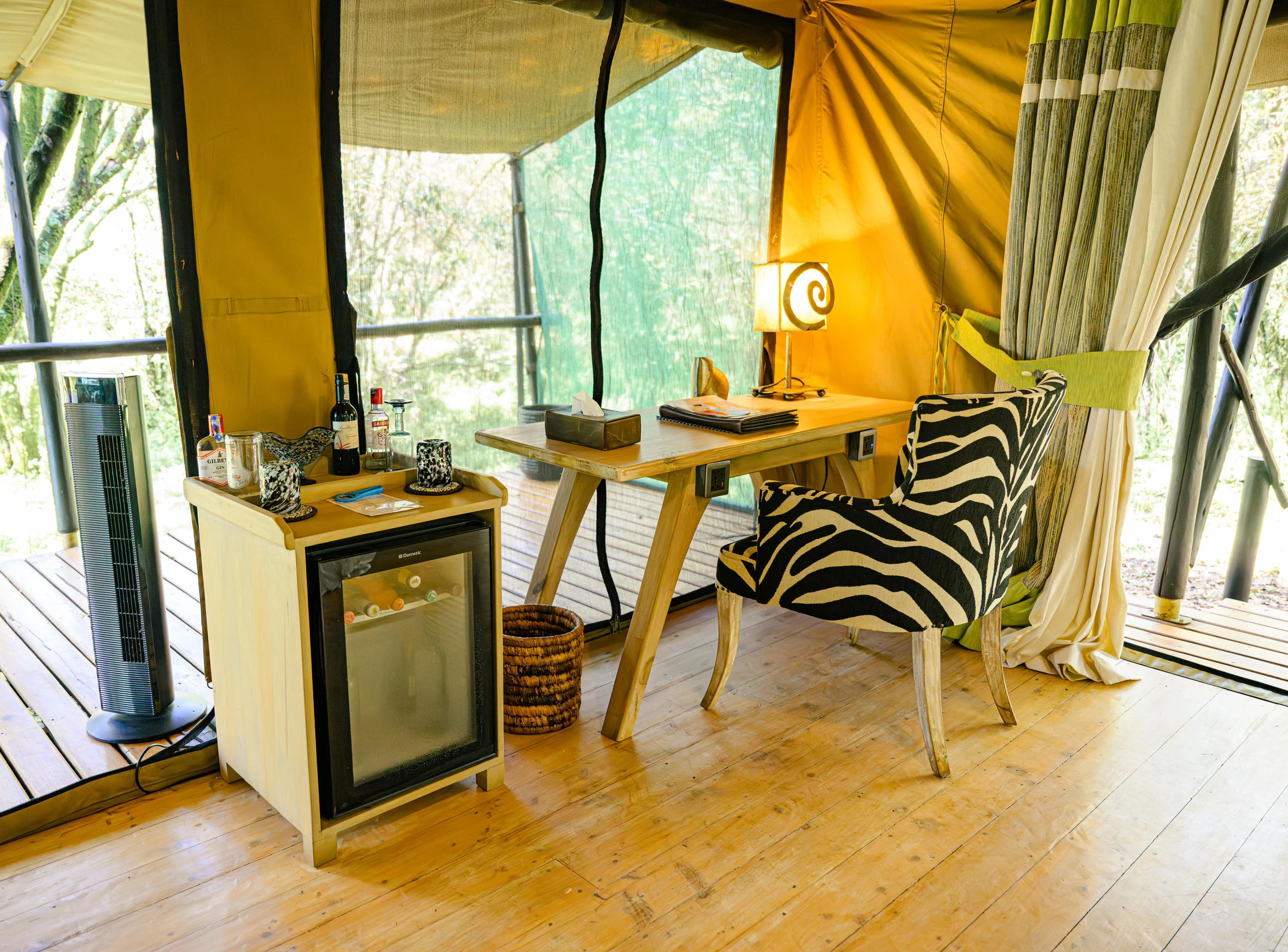 A tent sitting area with a desk and a zebra-print chair