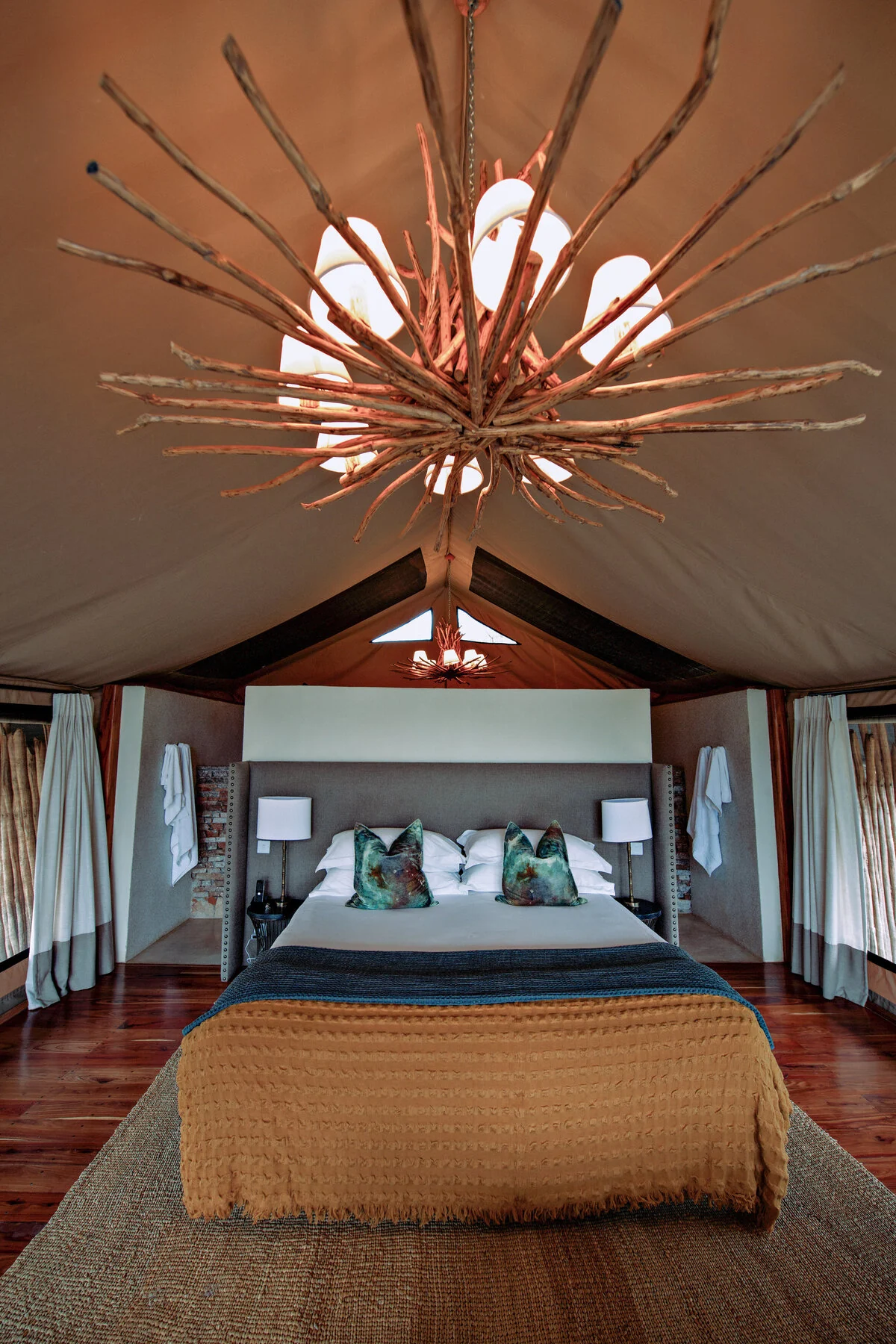 A tent bedroom beneath a timber-framed roof