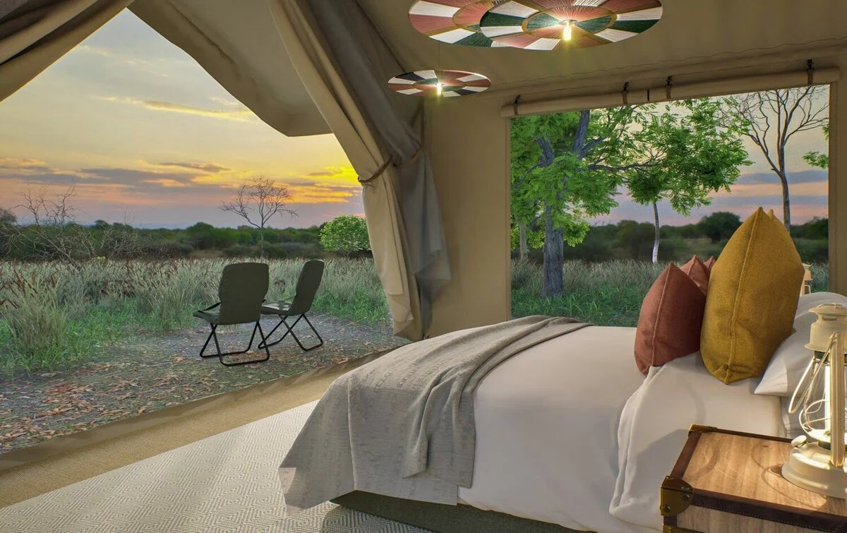 A tent bedroom looking out to the plains at sunset