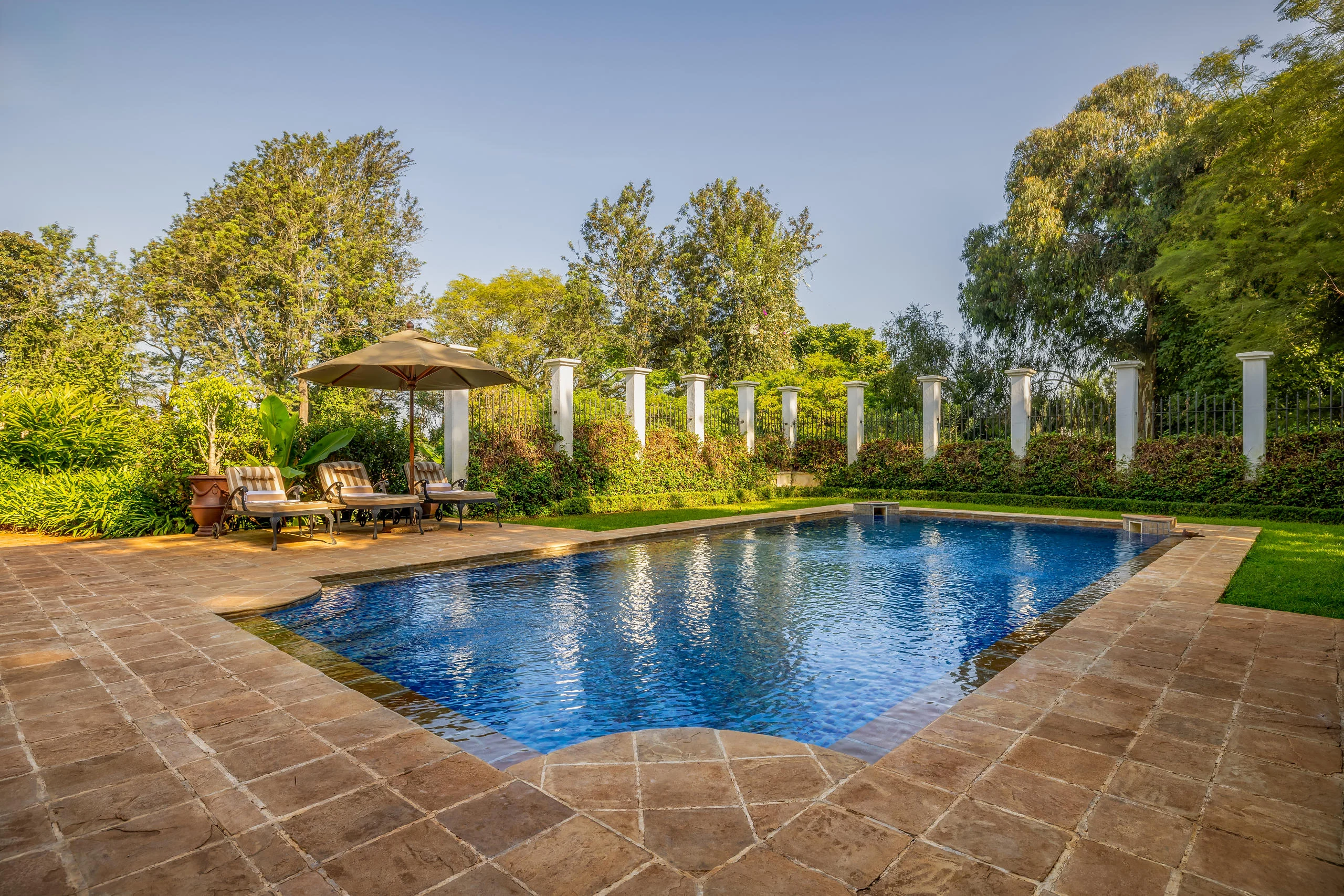 The pool with a parasol and loungers