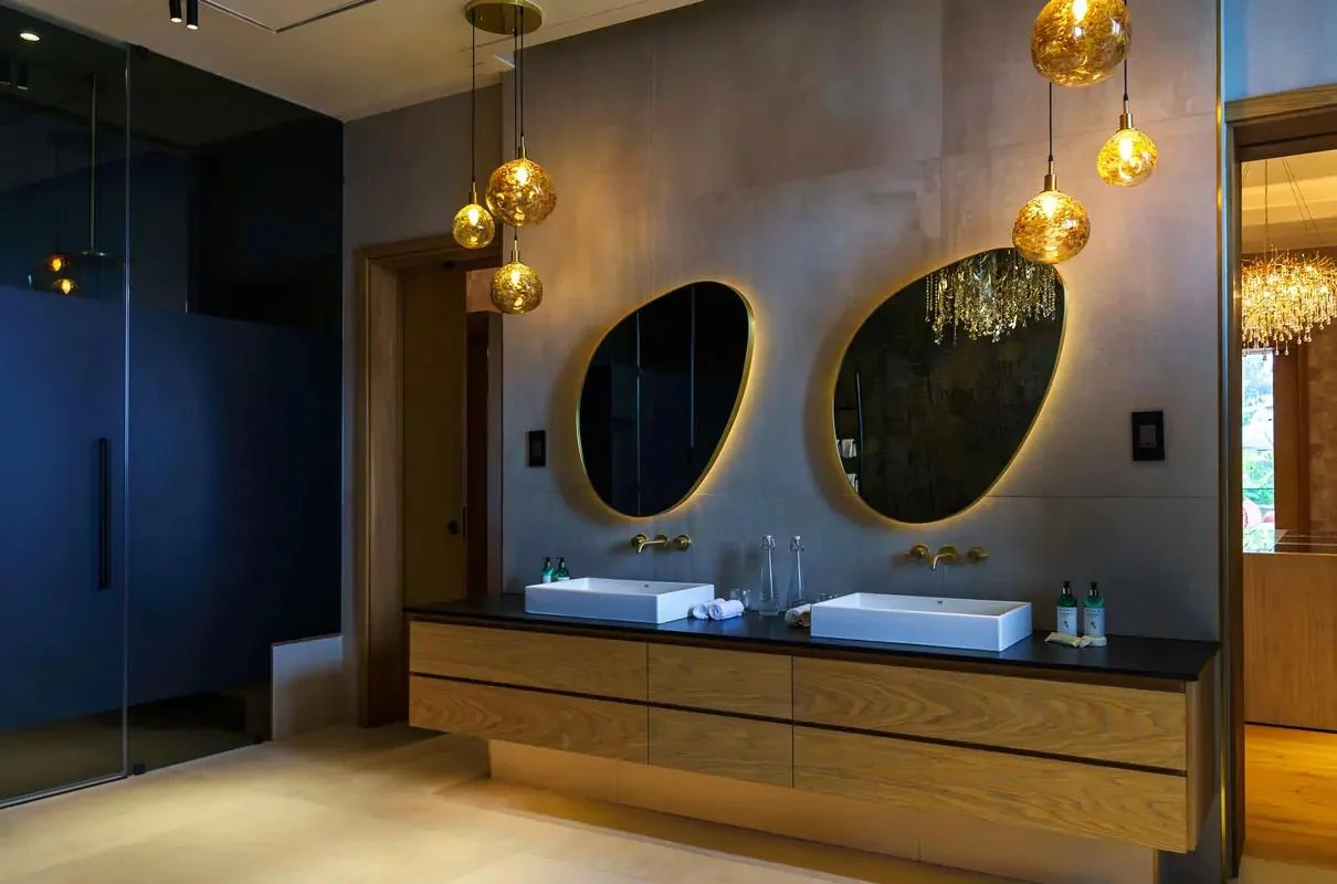 A bathroom with twin basins and round mirrors