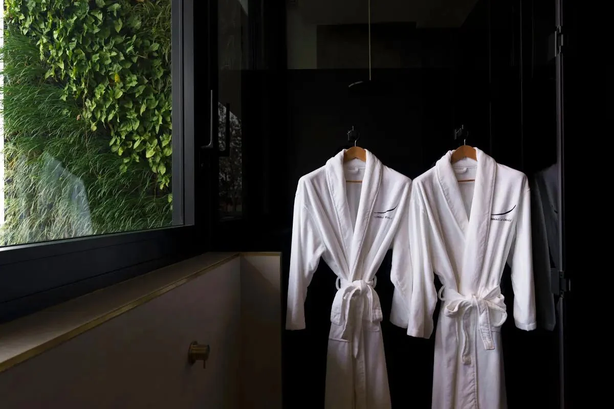 Dressing gowns hanging beside a green wall