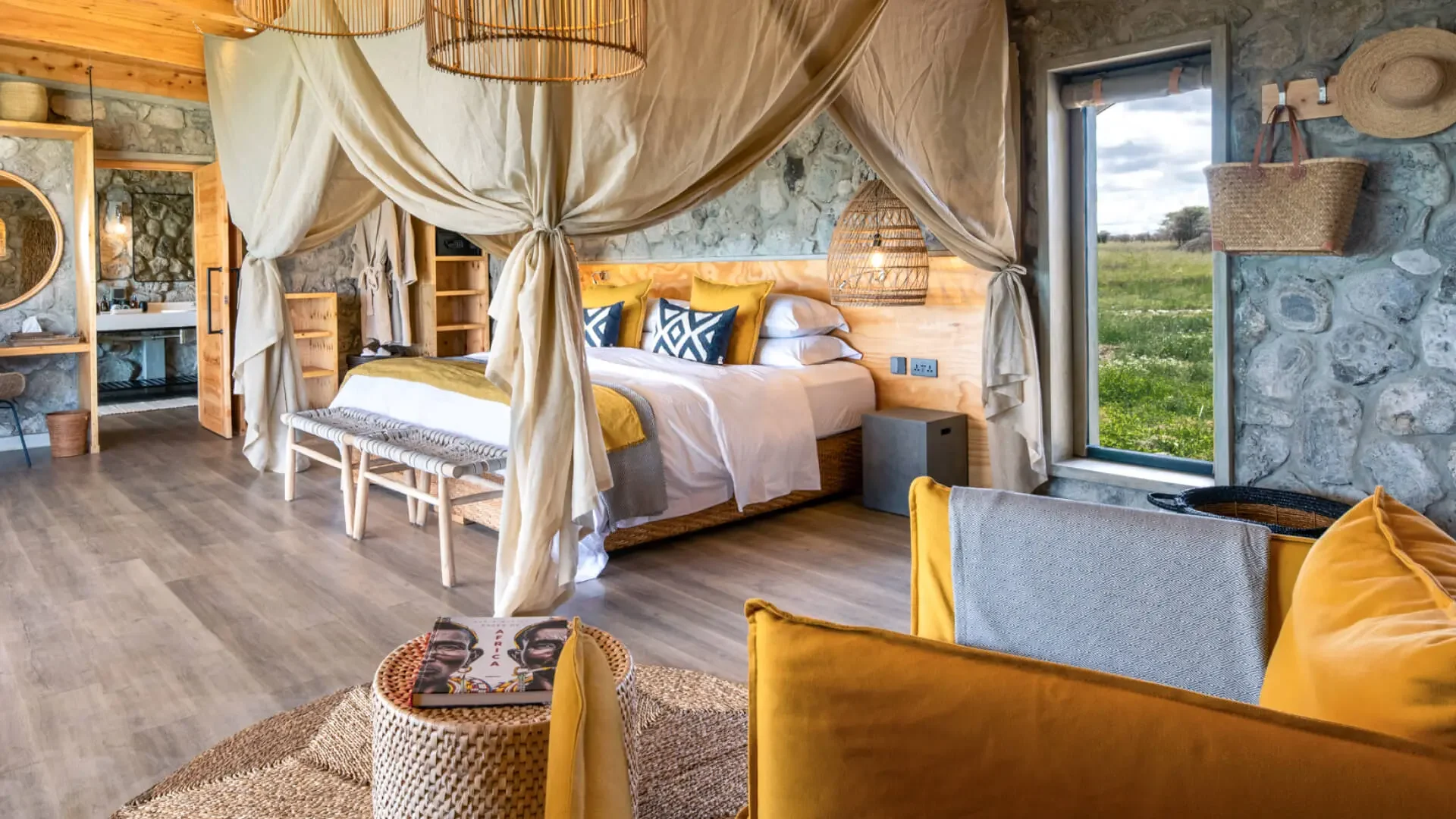 A bedroom with a draped bed and a yellow sofa