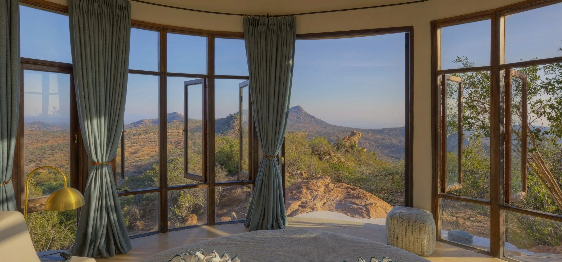 A bedroom with doors open to the hills