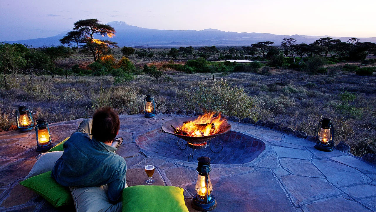 Guests at the fire pit with Kilimanjaro at dusk