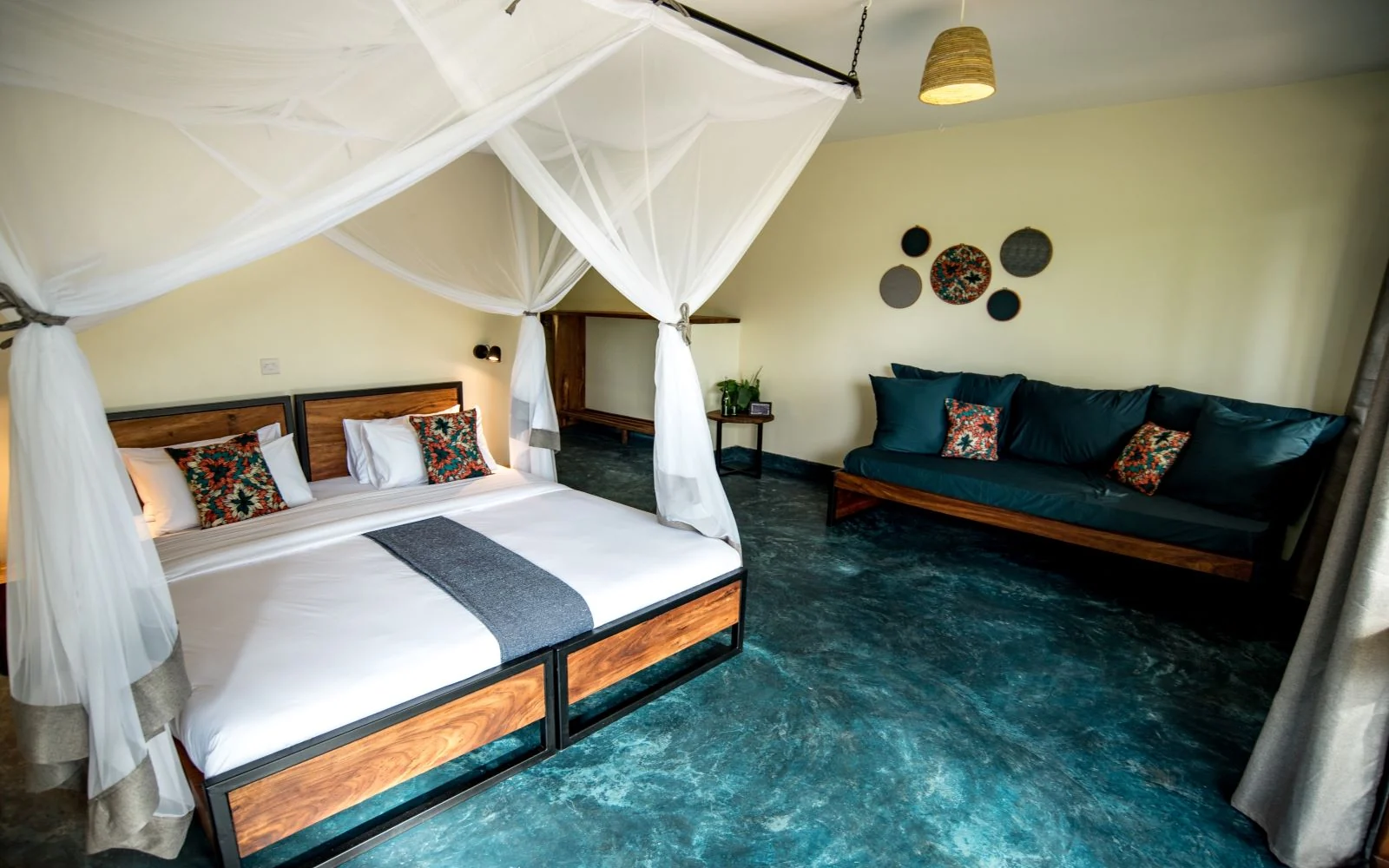 A bedroom with a draped bed and a sofa