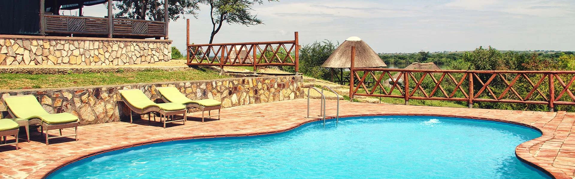 The pool with loungers and thatched shelters