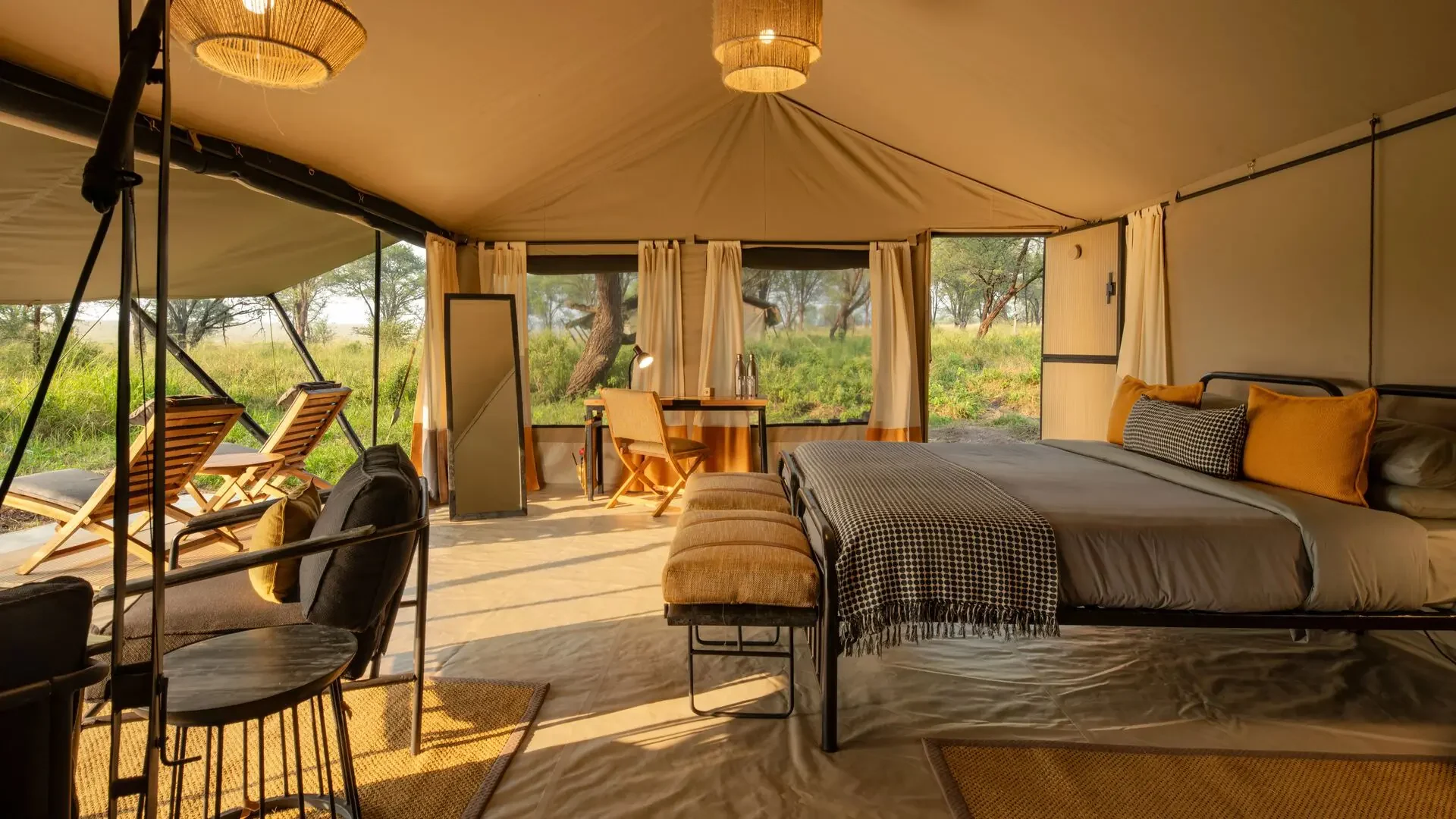 A tent bedroom with a desk and chairs