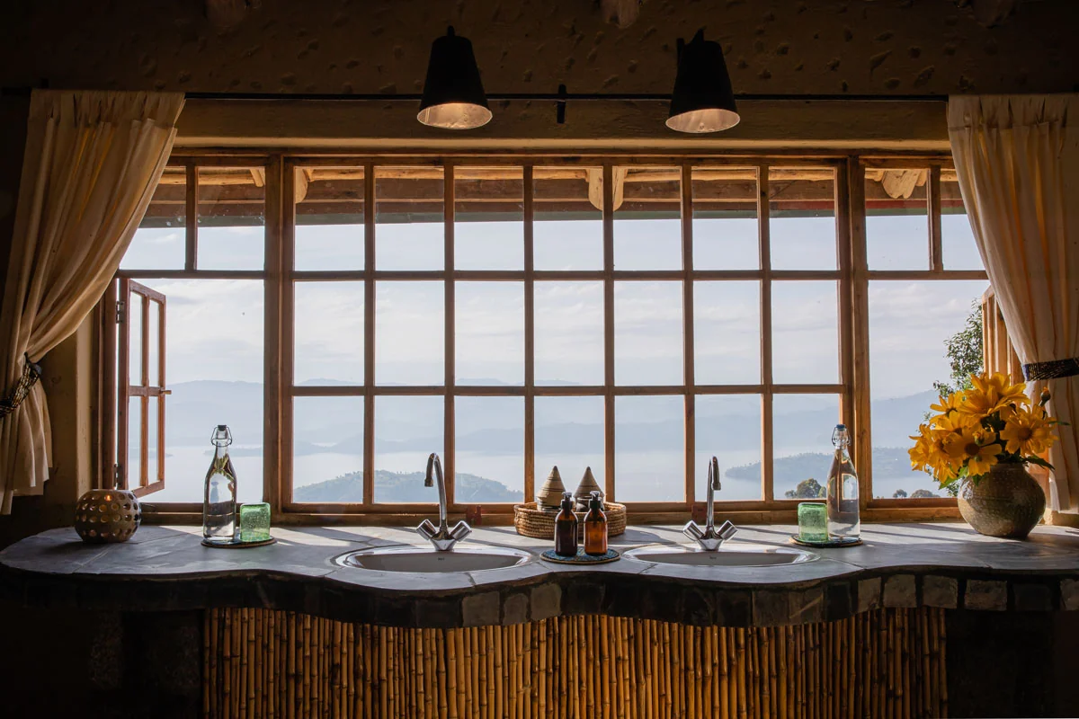 A bathroom with twin basins beneath a window onto the lakes