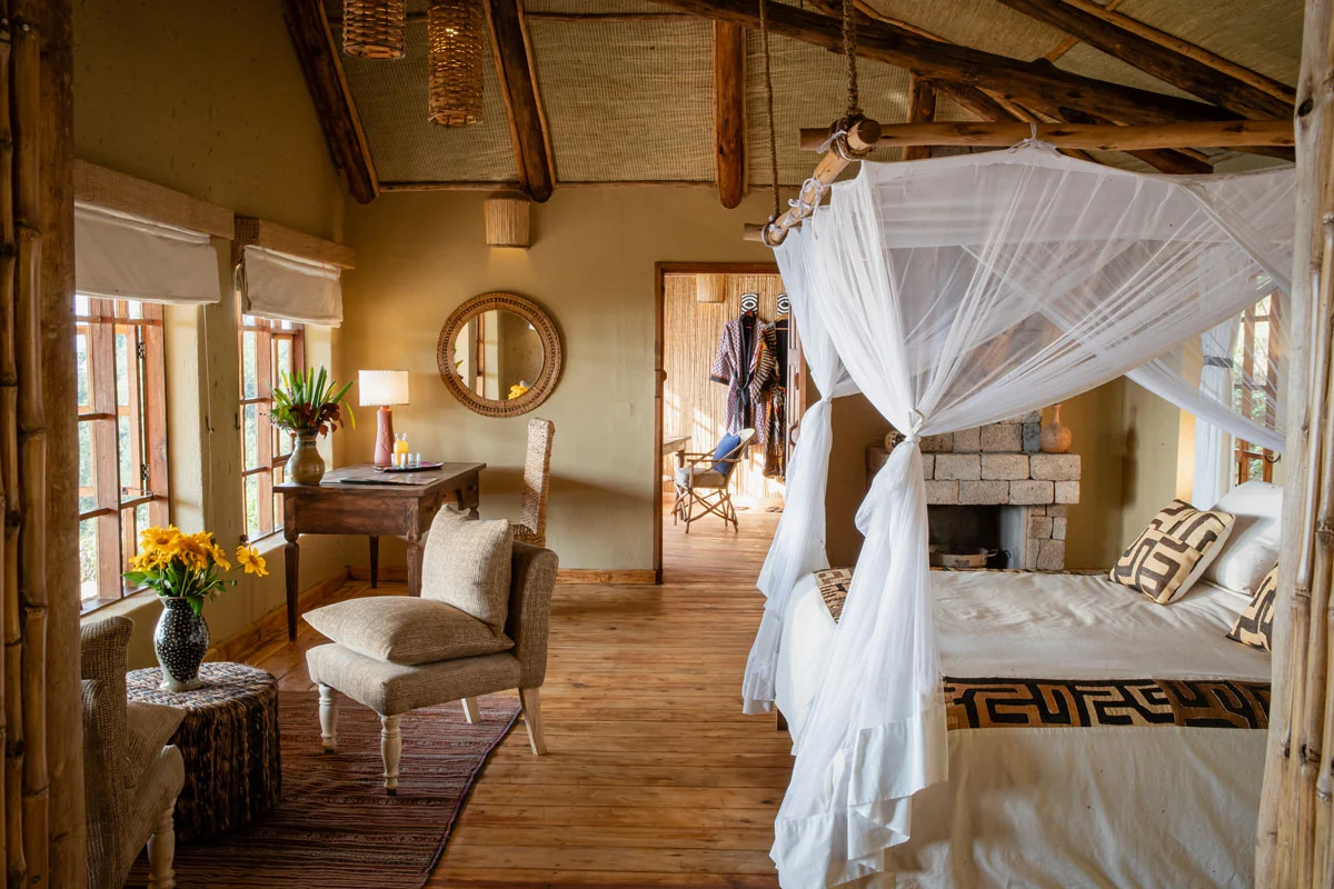 A banda bedroom with a draped bed and a fireplace