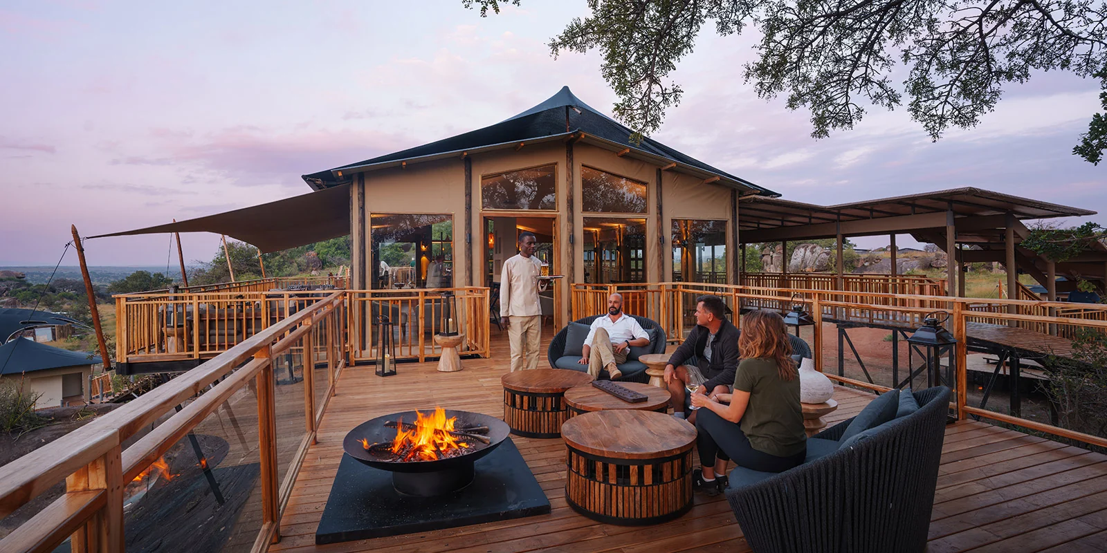 Guests around the fire on the main deck at dusk