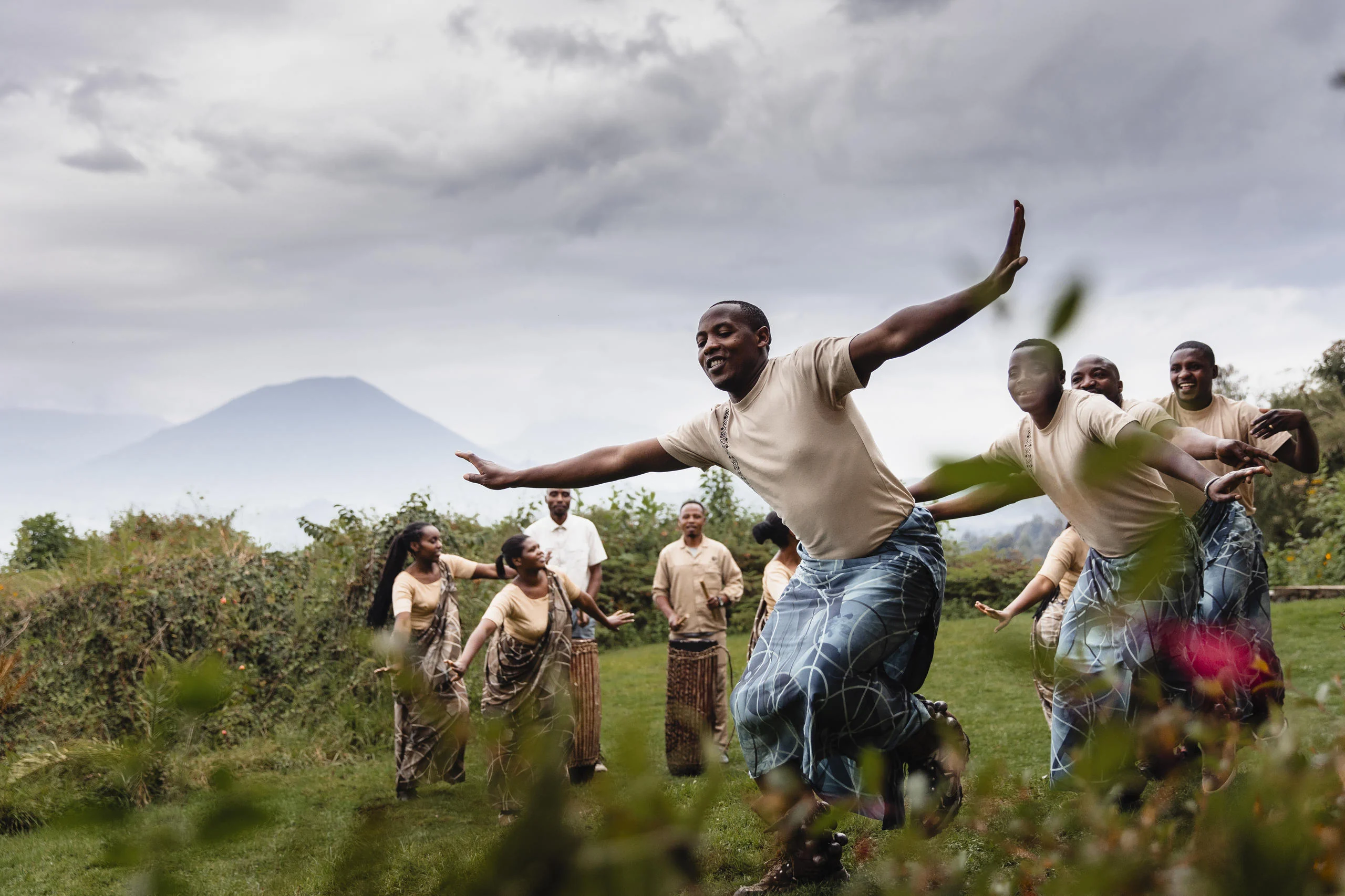 Dancers performing on the lawn with a volcano behind