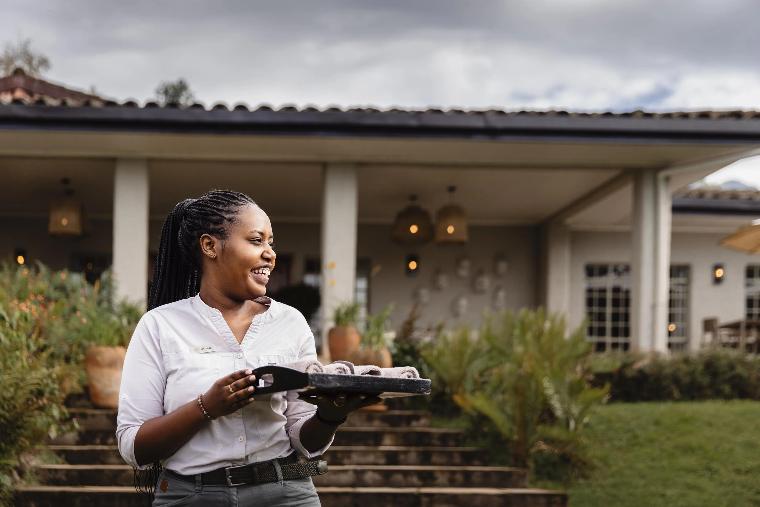 A member of staff carrying a tray on the lawn
