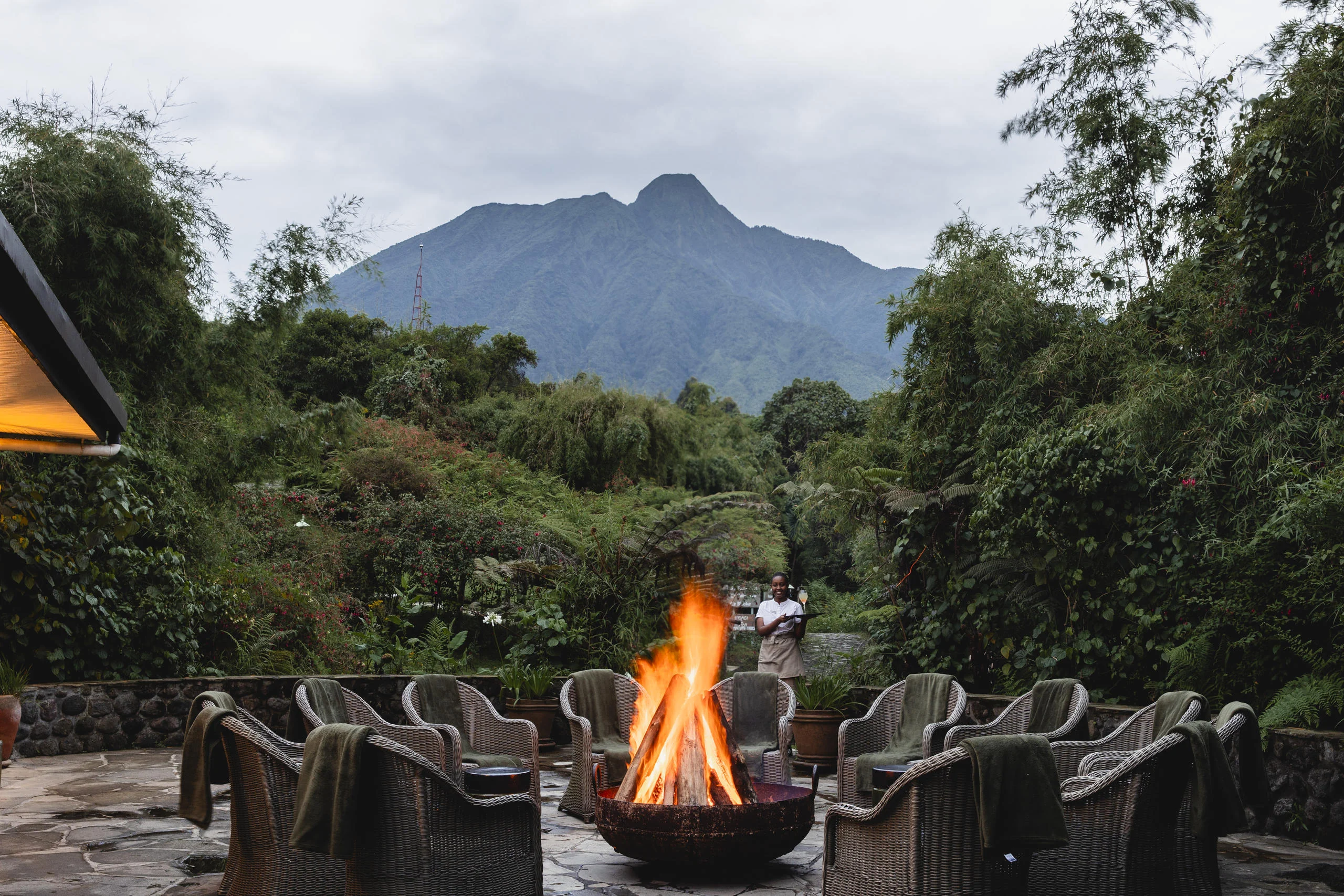 Chairs around a fire at dusk with the volcano behind