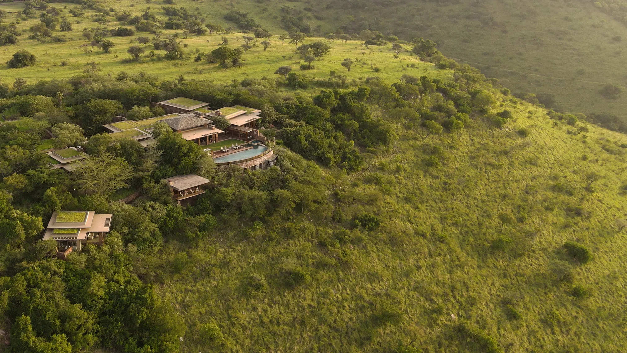 Aerial view of Singita Kilima set among trees above the Serengeti plains