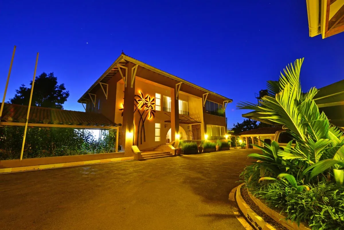Hotel No.5 in Entebbe at dusk, its entrance lit beneath a deep blue sky